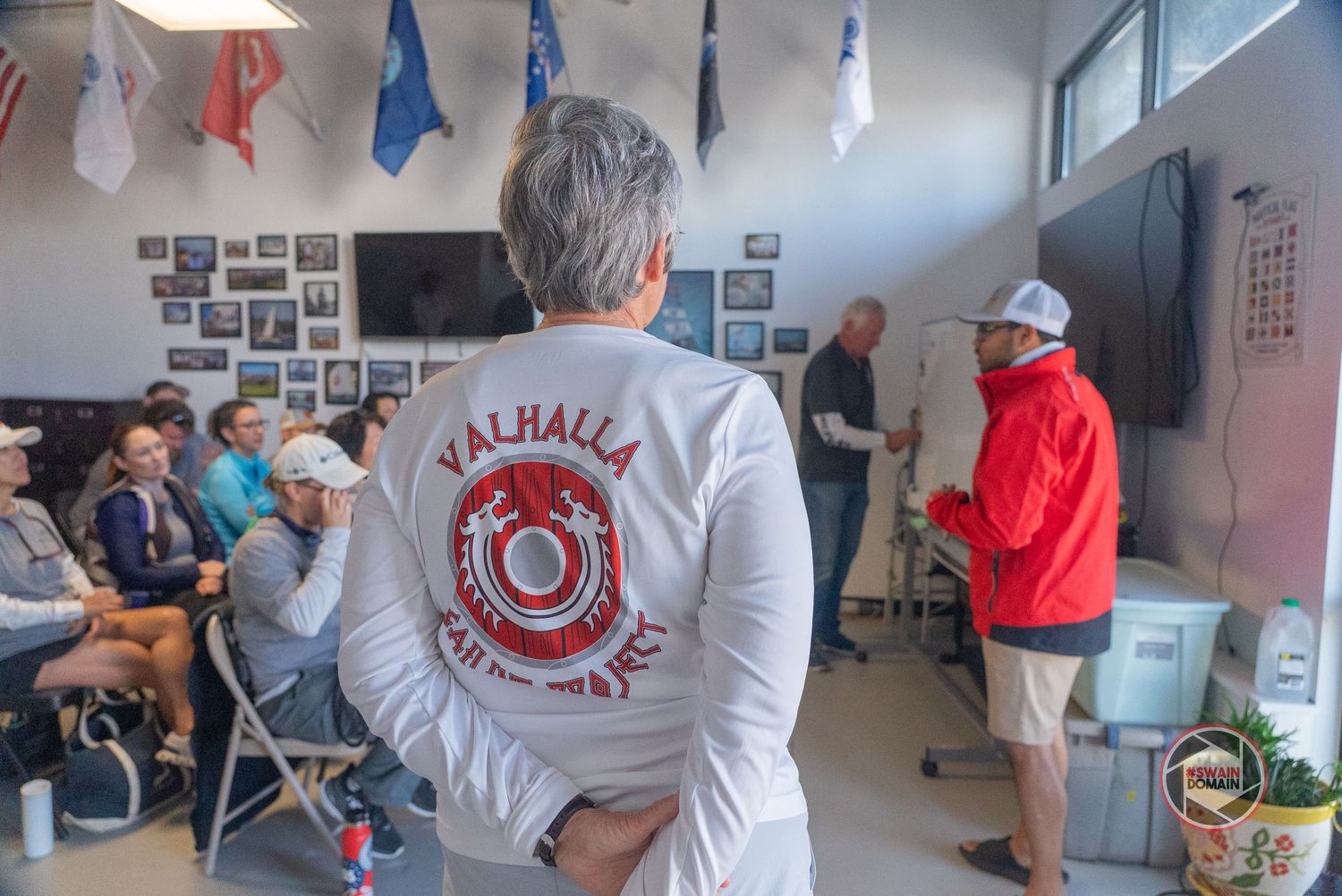 Students collaborate on projects in a bright classroom with white walls and photo displays.