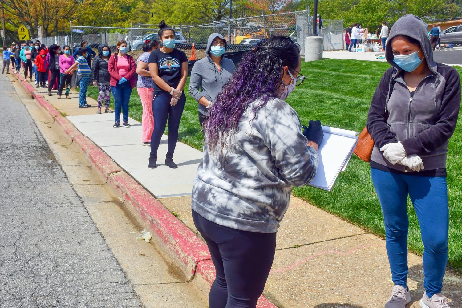 Crowd of people walking along outdoor pathway during community event.