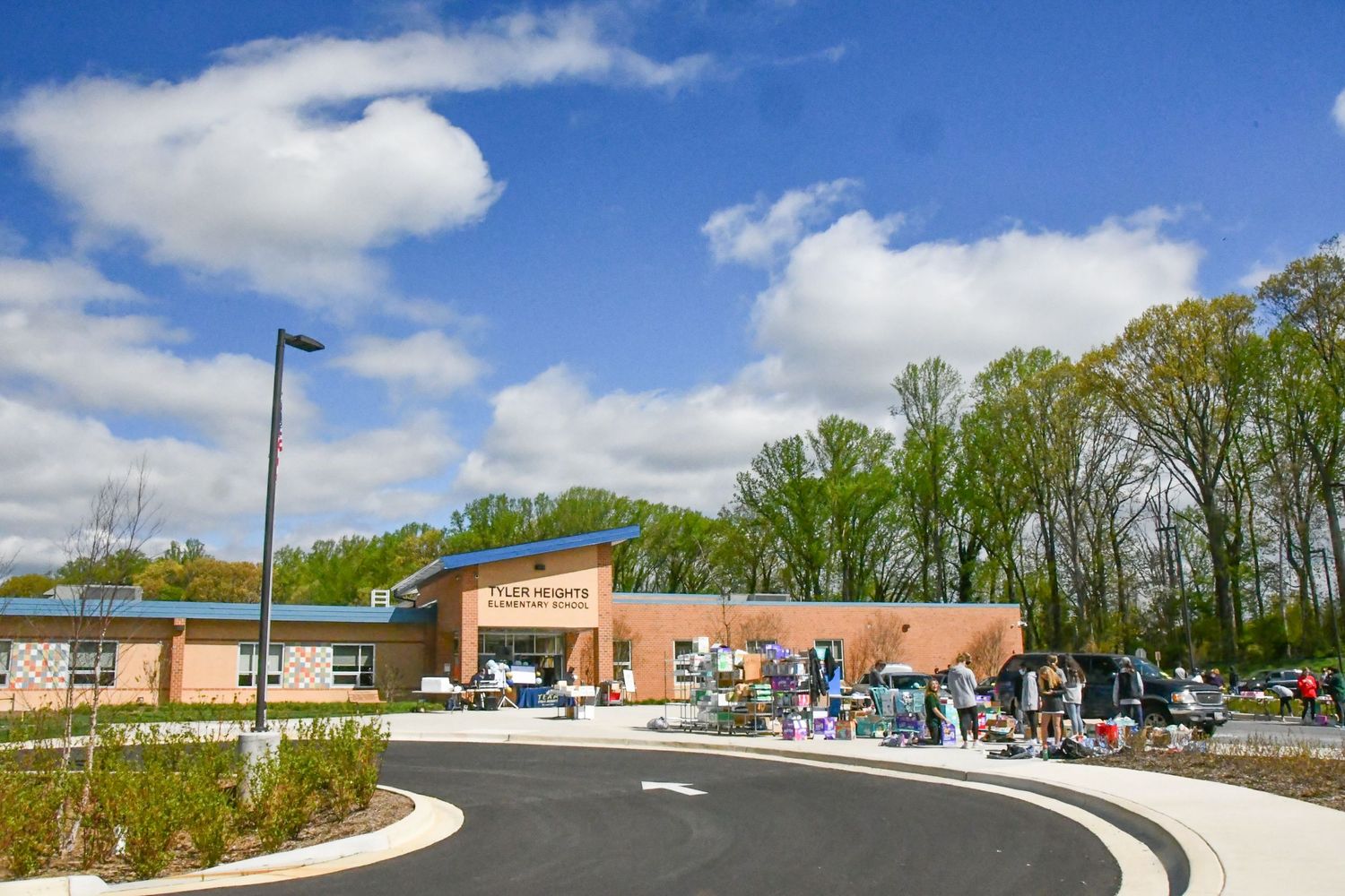 Wide panoramic view of a parking lot and buildings on a sunny spring day.