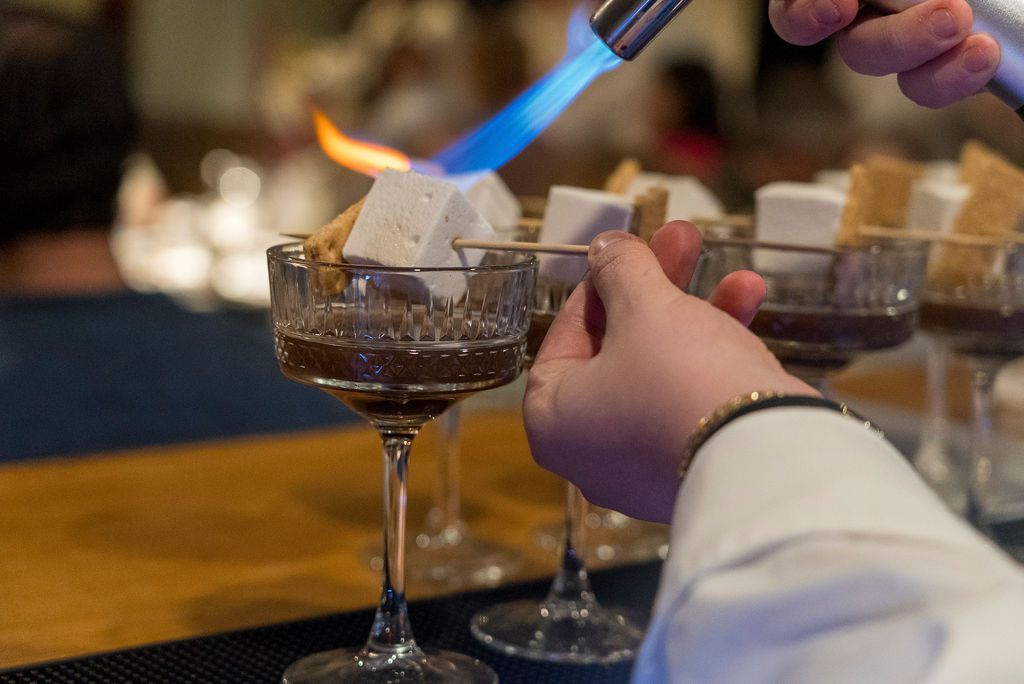 Wine glasses and drinks being served at an elegant event.