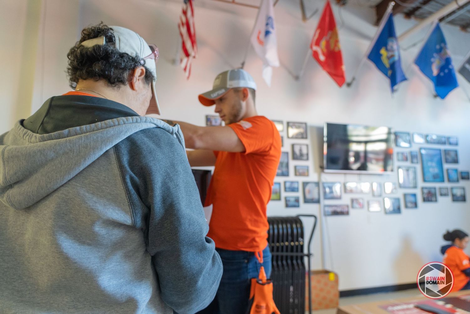 Students work on projects in a bright classroom decorated with blue and red banners hanging from the ceiling.