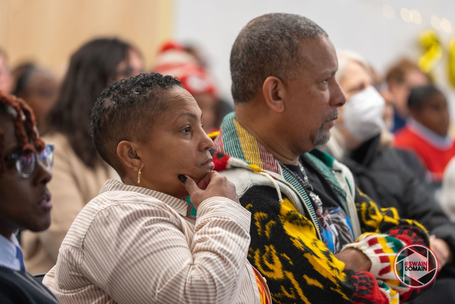 Audience members seated and listening attentively during a presentation.