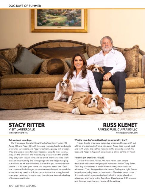 People relaxing with their St. Bernard dogs on a beige couch in an elegant living room setting.
