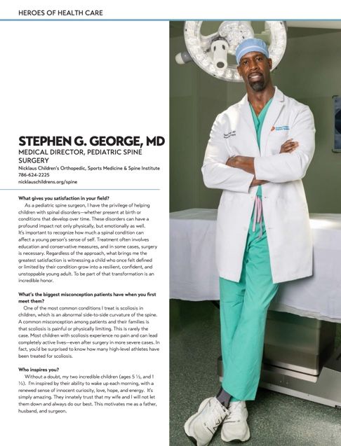 Medical professional in white coat and teal scrubs poses confidently against hospital wall with surgical light in background.