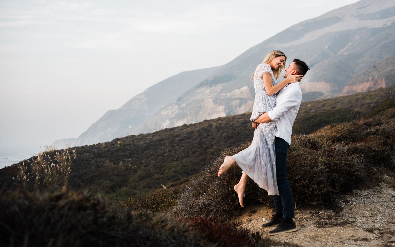 Dramatic coastal cliffside photography sequence with mountains in the background.