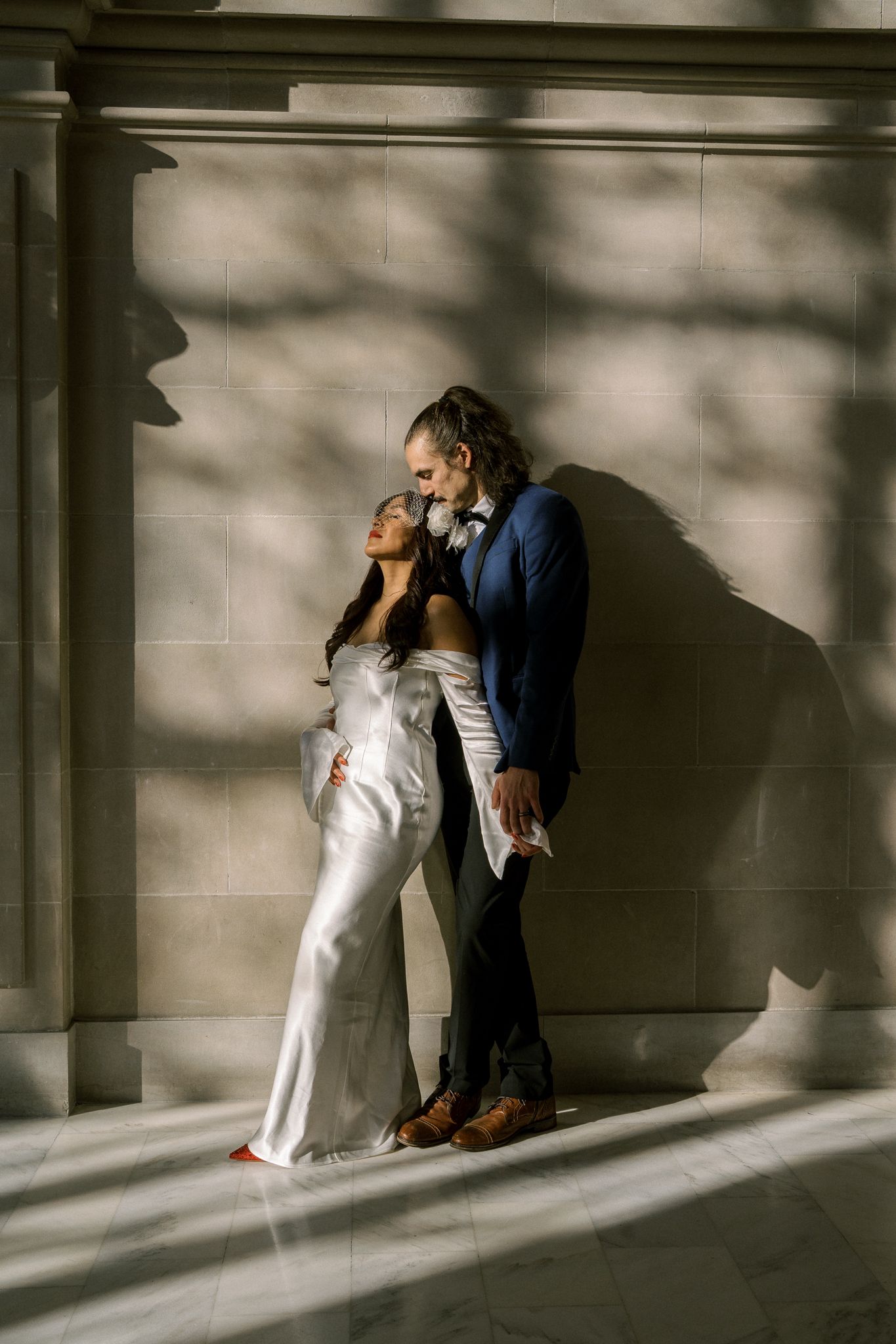 Artistic wedding photos showing couple against dramatic shadows and architectural columns.
