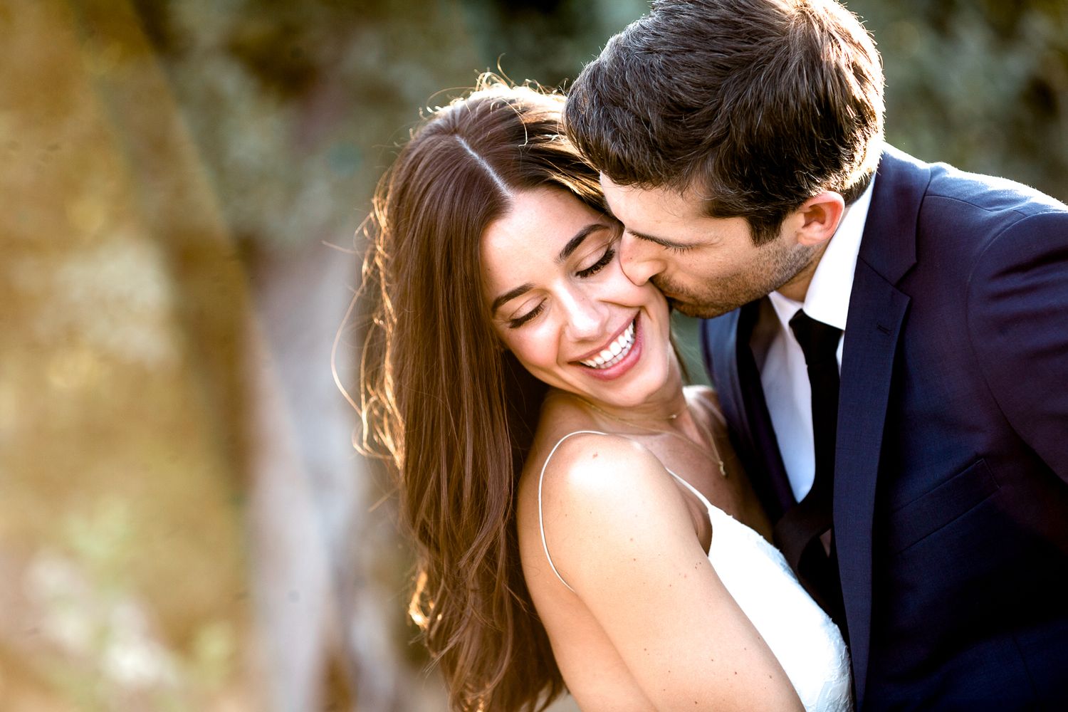 Candid romantic moments captured between newlyweds in soft golden light.