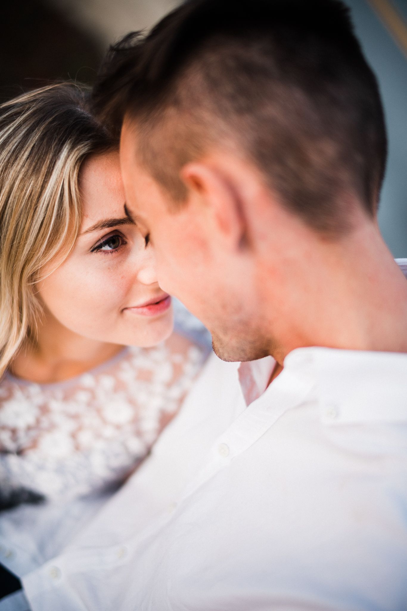 A tender close-up moment between a couple in soft natural lighting.