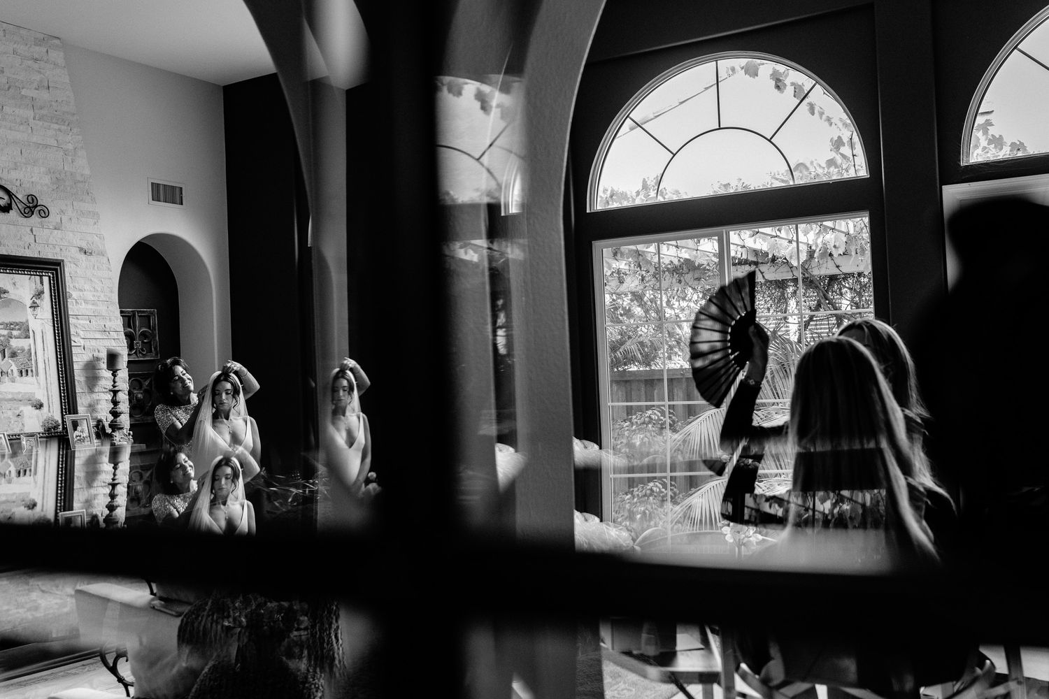 Black and white architectural interior with arched windows and silhouettes creating dramatic shadows.