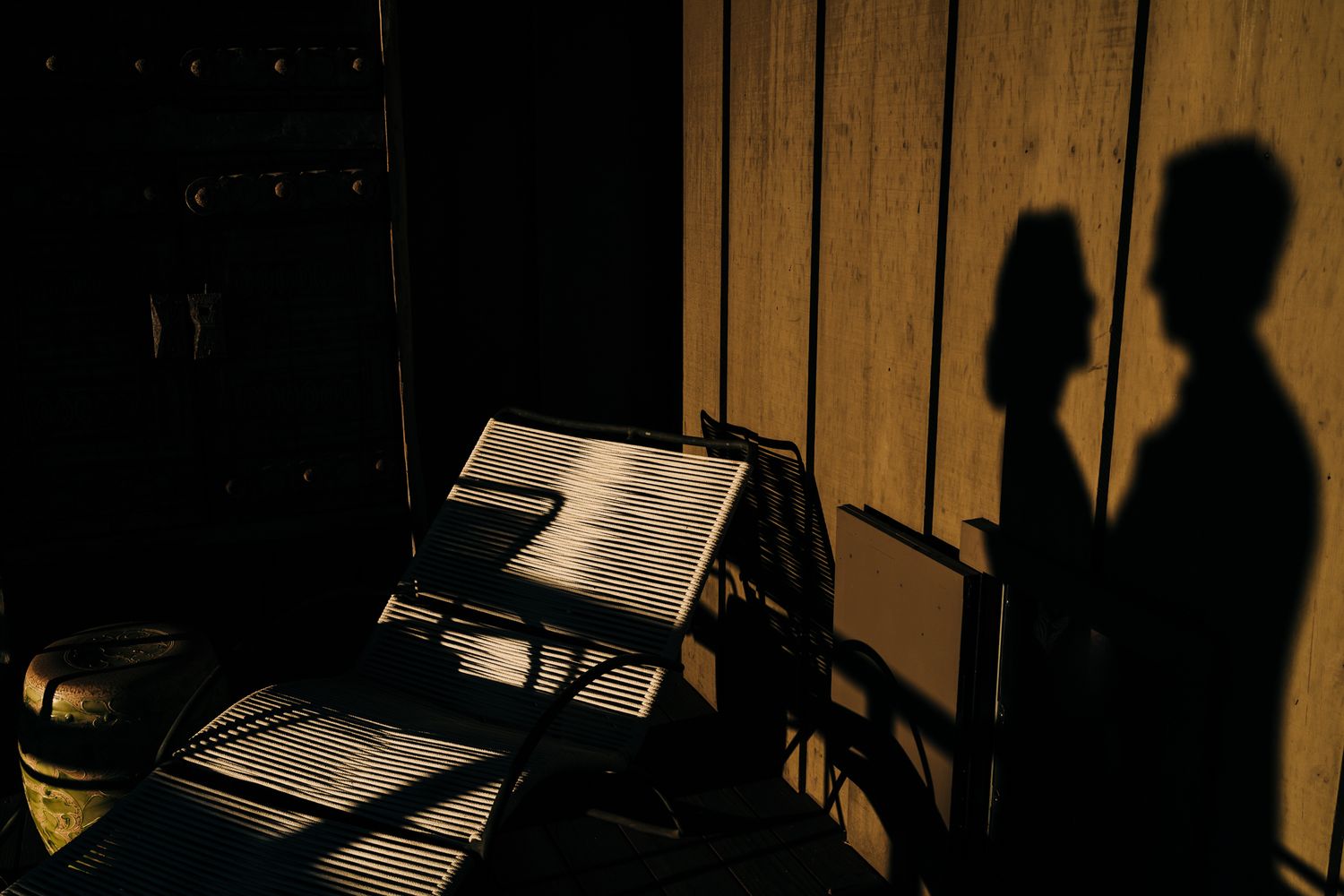 Shadow play on wooden walls creates dramatic patterns in warm lighting.