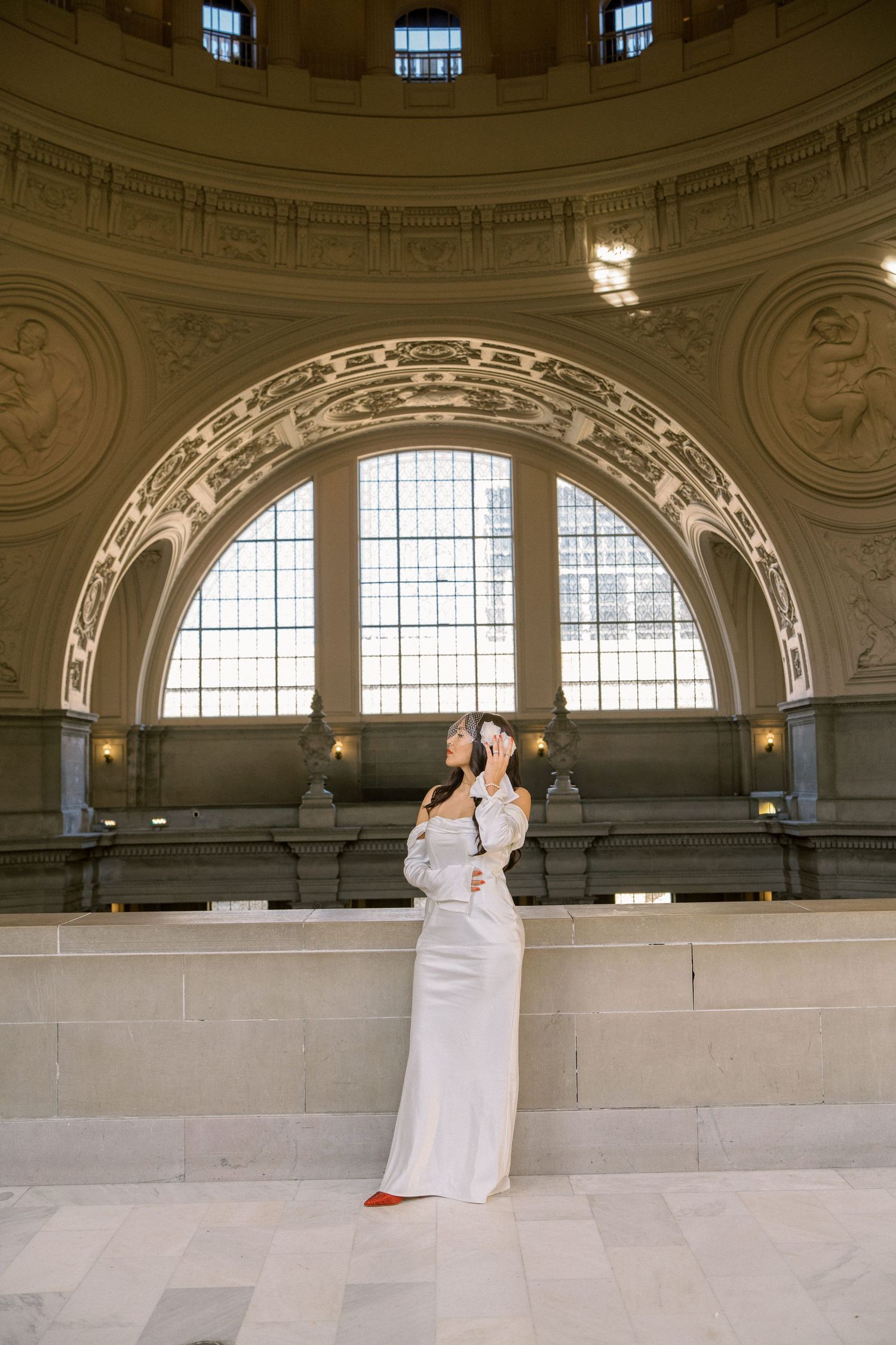 A panoramic view of a grand historic ballroom with ornate architectural details and arched windows.