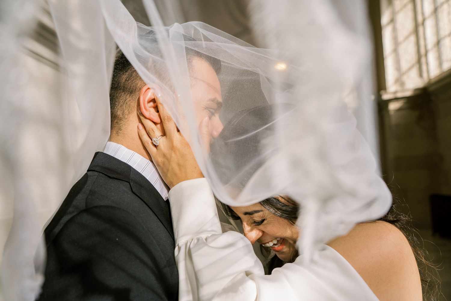 Intimate wedding portraits with flowing white veil creating romantic atmosphere.