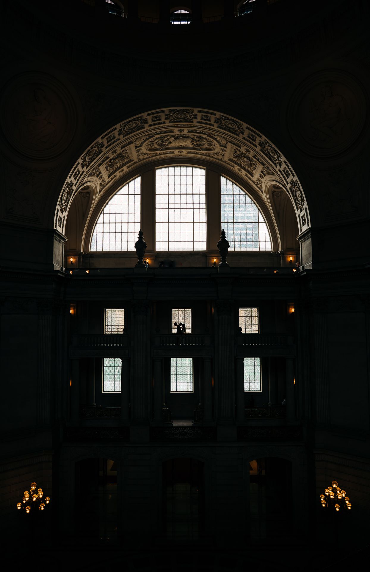 An architectural interior shot of an ornate arched window with dramatic lighting.