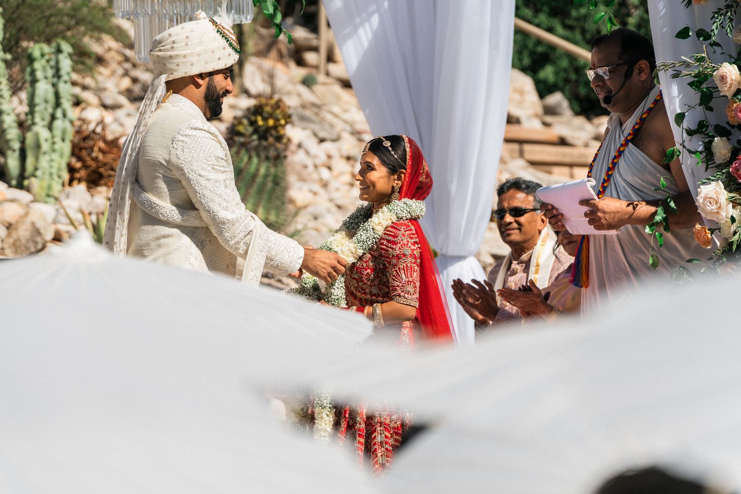 Traditional Indian wedding ceremony with white draping and decorative elements.
