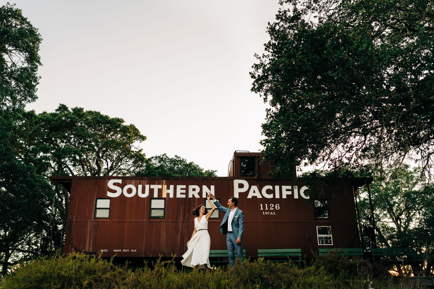 Southern Pacific train cars and signage with trees in background during golden hour.
