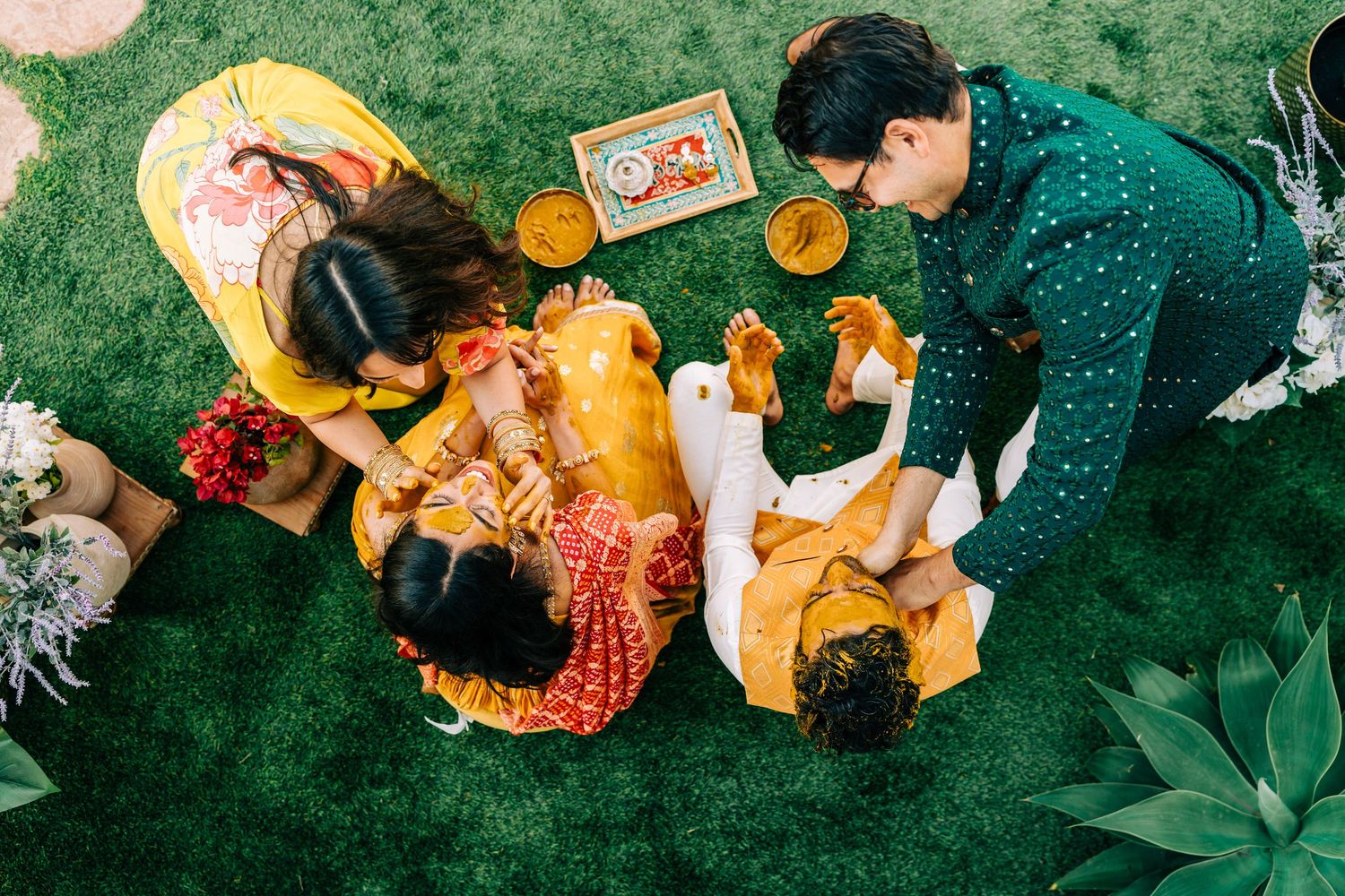 Bird's eye view of traditional Indian wedding ceremony items and decorations on green grass.