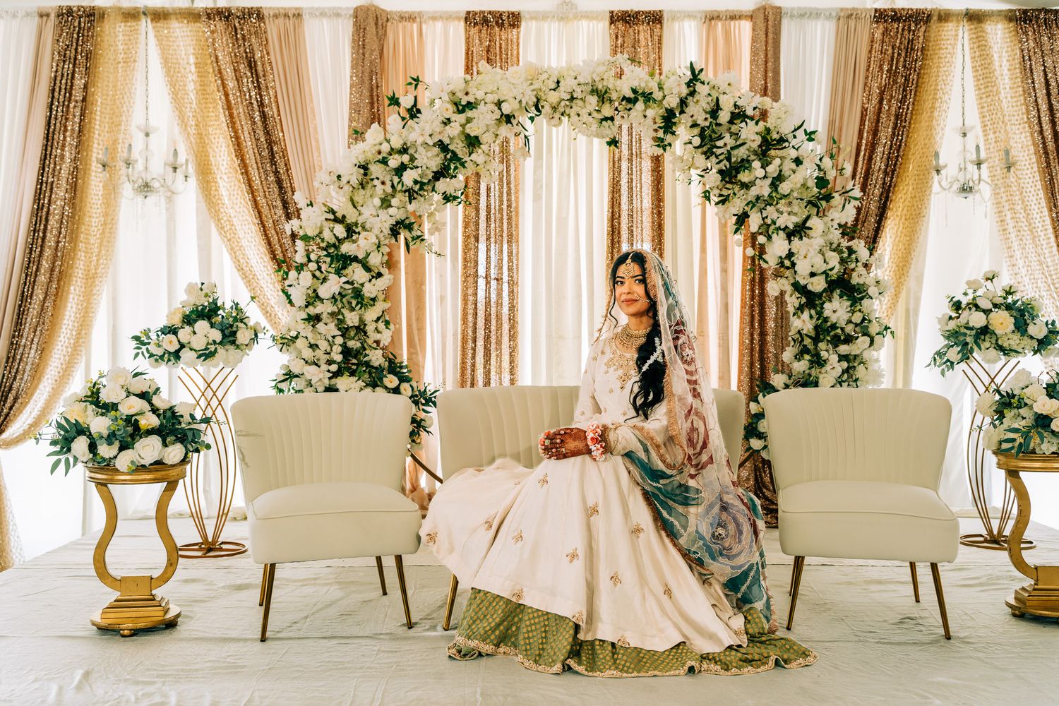 Elegant wedding venue decorated with cream drapes and floral arrangements creating a romantic ambiance.