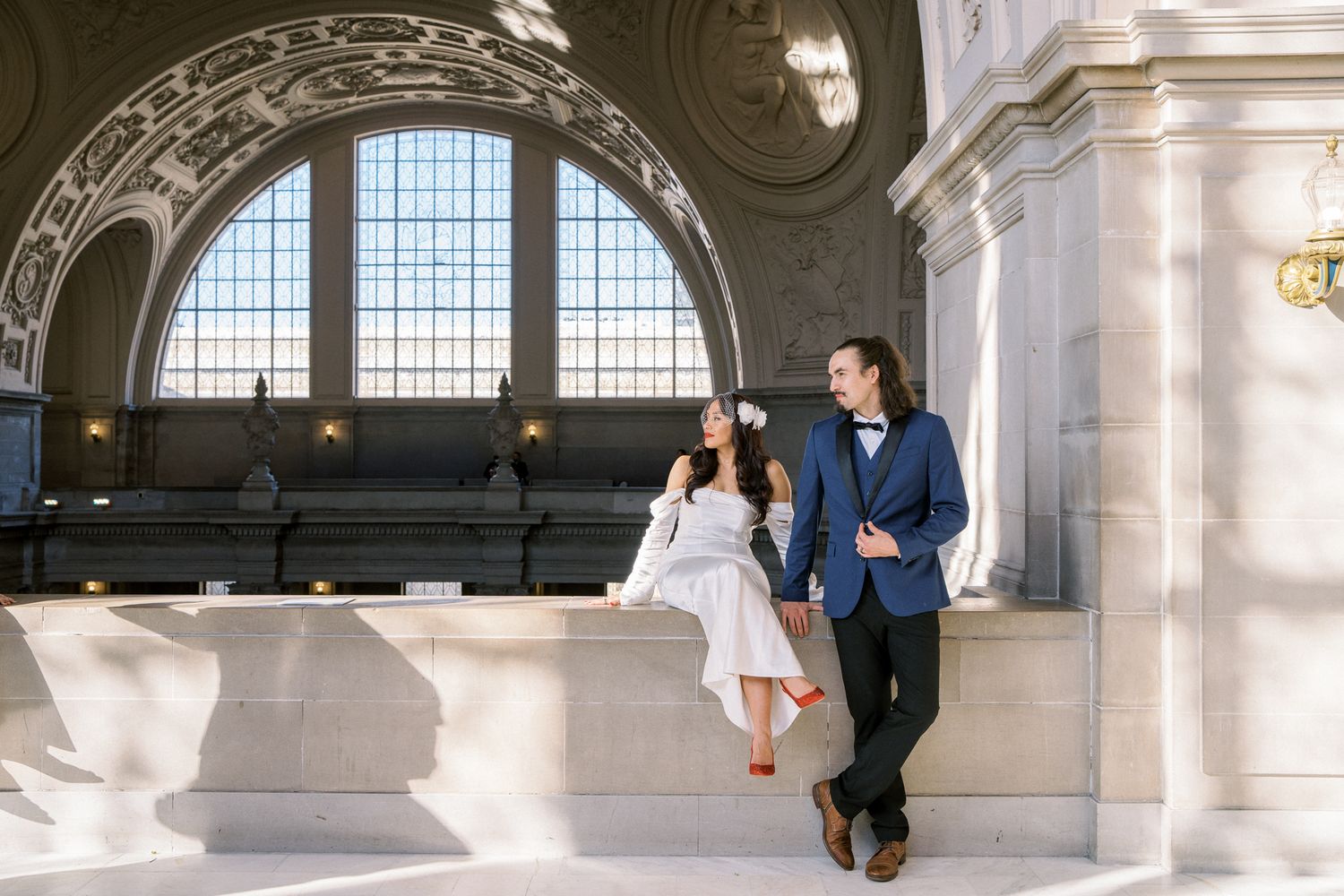 Elegant wedding photos taken in a historic building with beautiful arched windows.