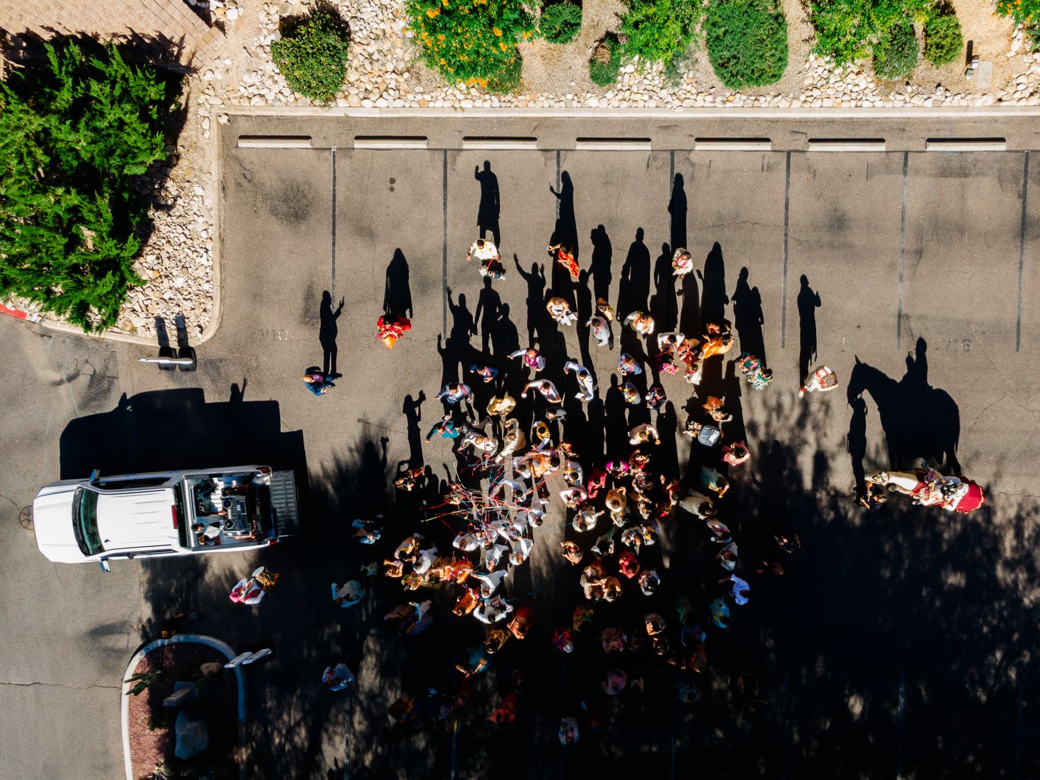 Aerial view of a large wedding gathering with guests forming patterns on concrete.