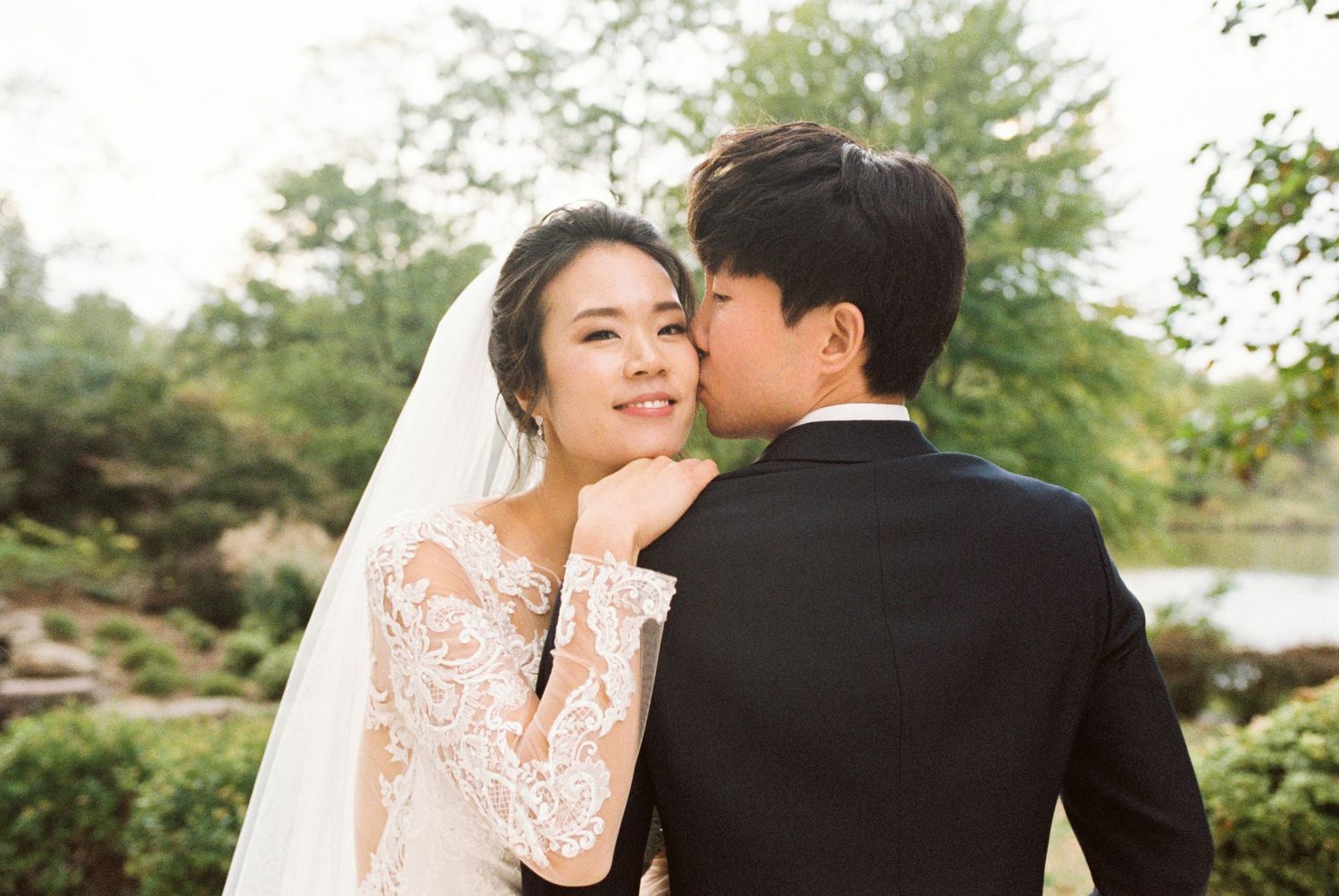 Romantic outdoor wedding portraits showing tender moments between newlyweds in garden setting.