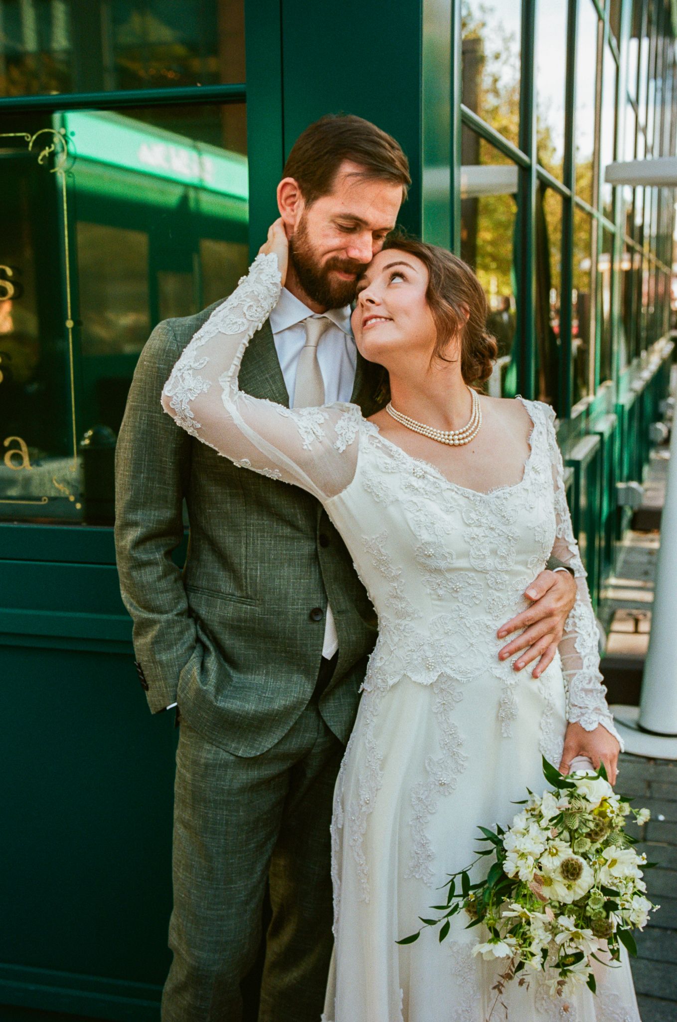 Romantic wedding portraits against green industrial doorway.