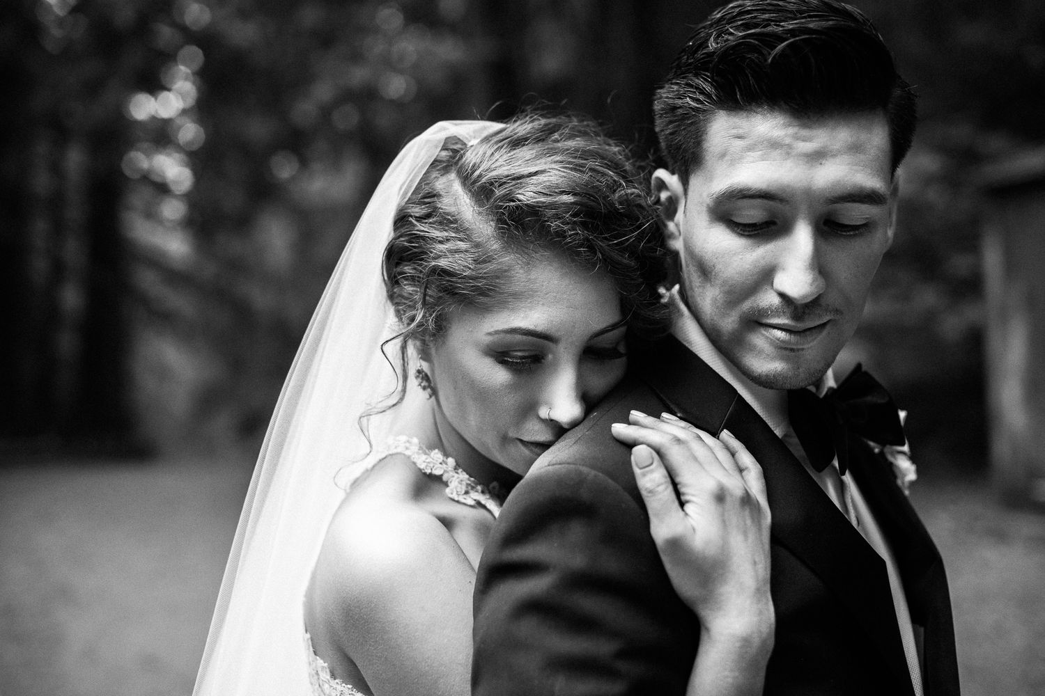 Intimate black and white wedding portraits in natural outdoor setting.