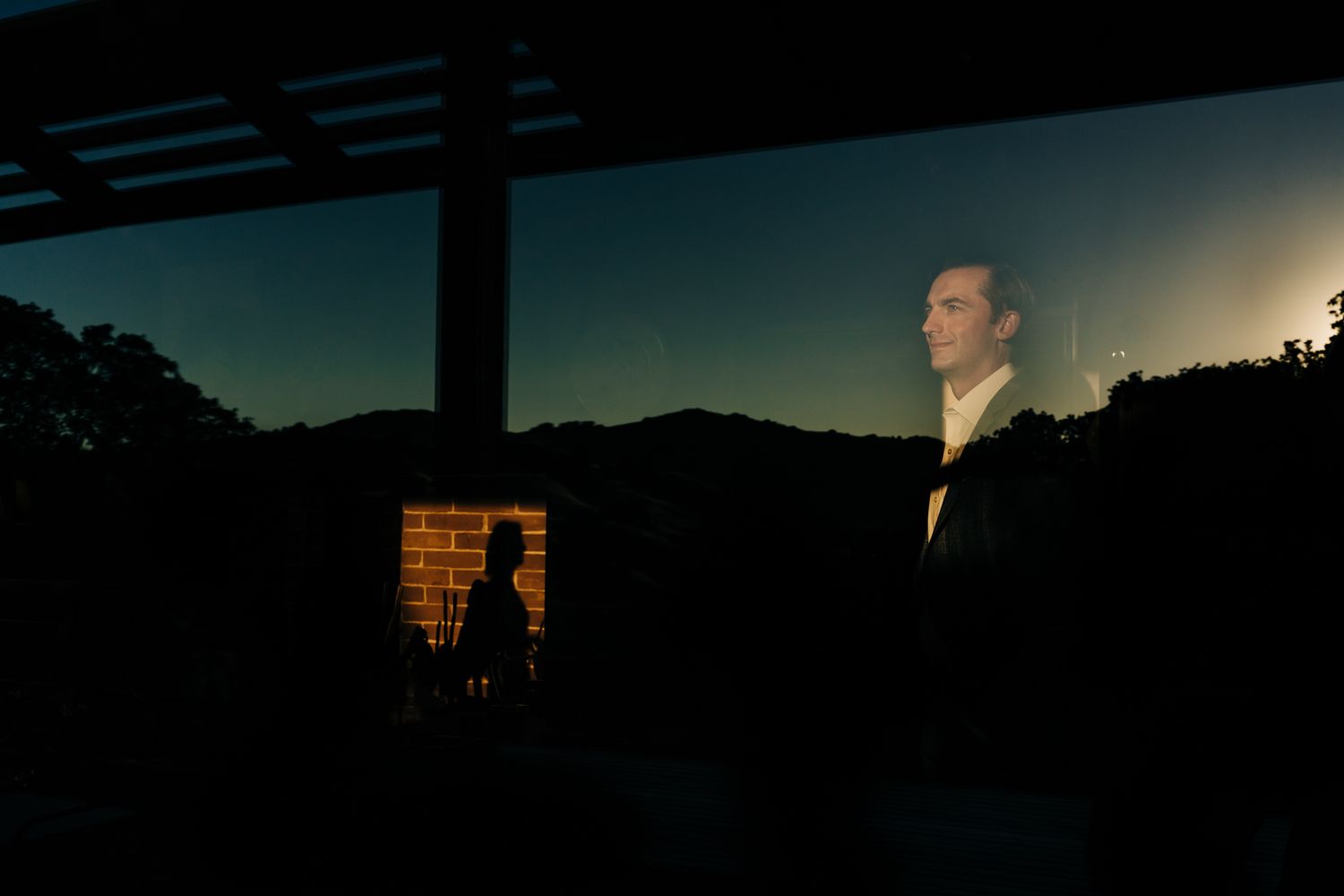 Dramatic sunset silhouettes against a mountain landscape with warm orange sky.