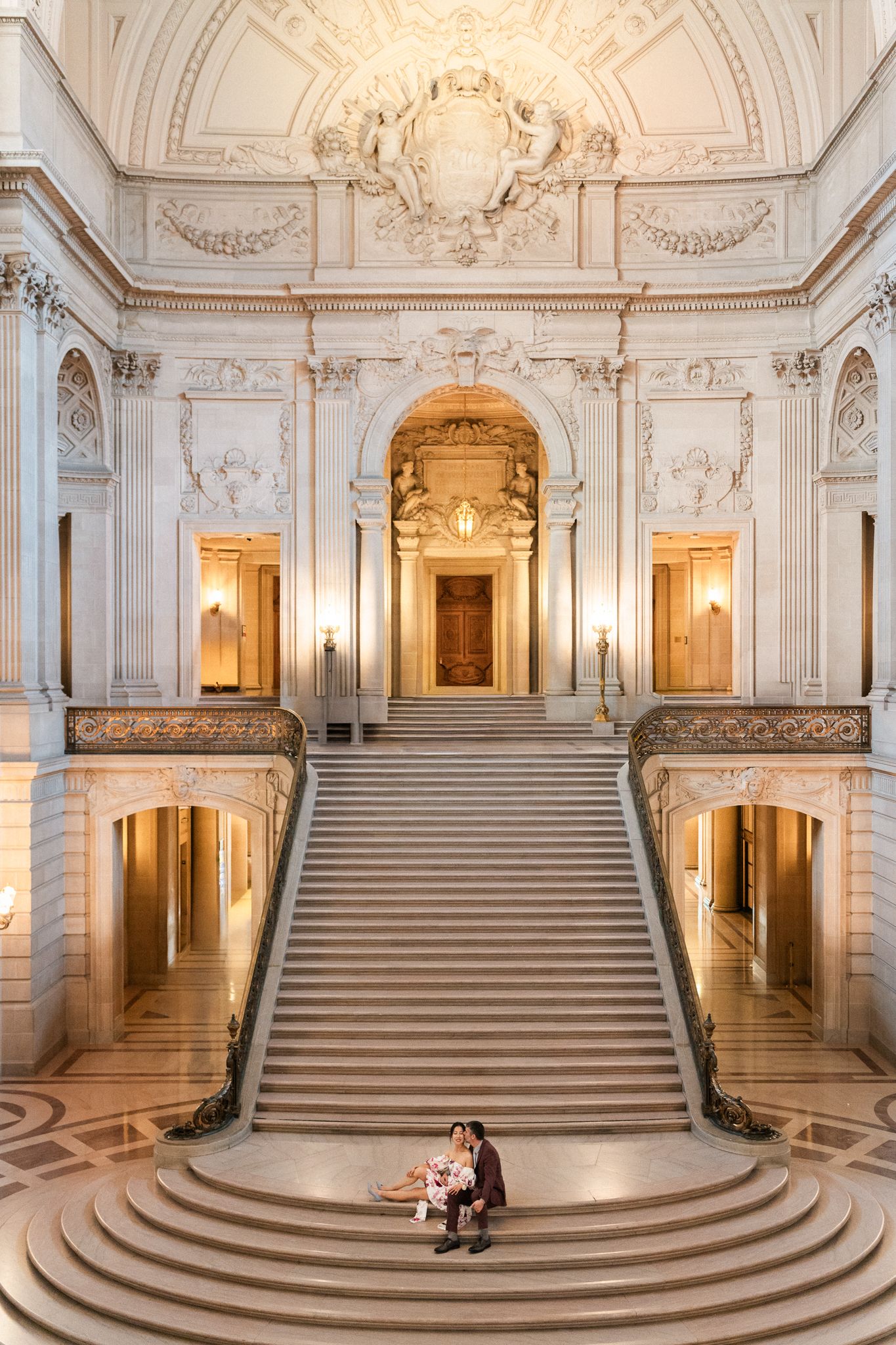 Grand marble staircase with ornate architectural details in historic building.