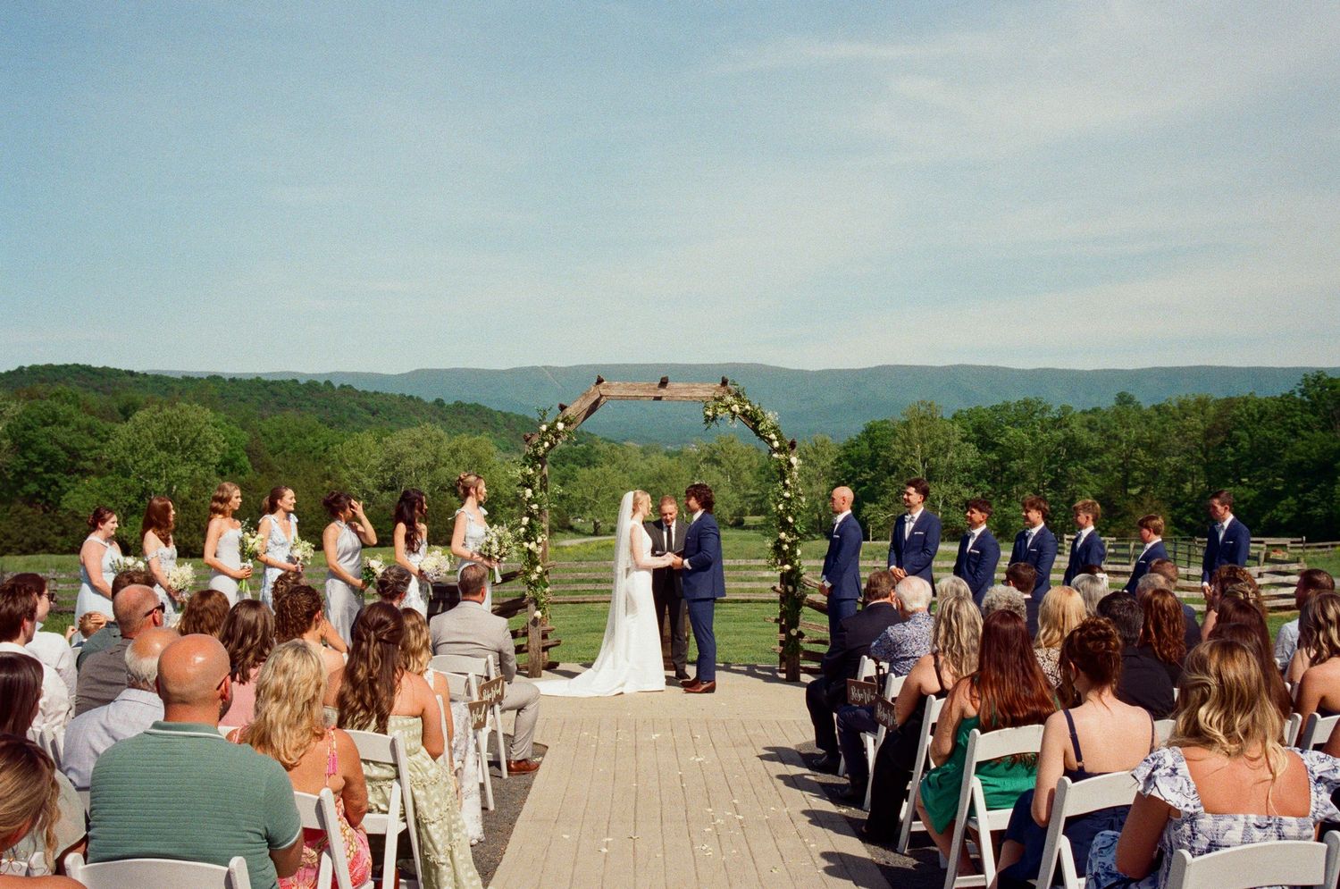 A panoramic view of an outdoor wedding ceremony with mountain vistas.