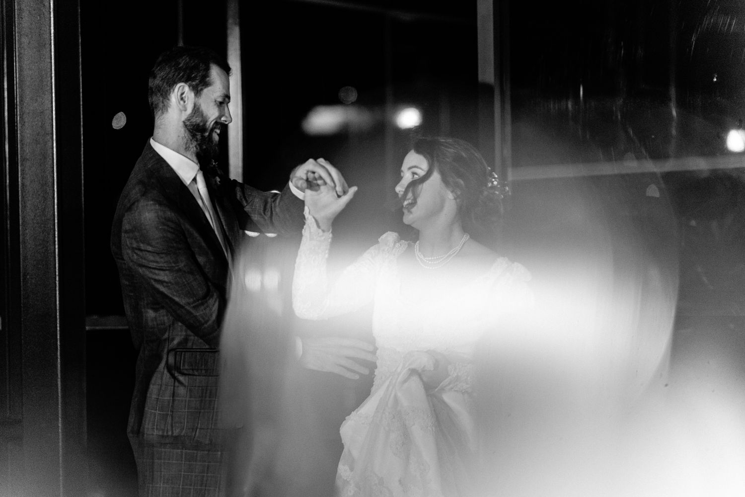 Black and white photo of a couple dancing at their wedding reception.
