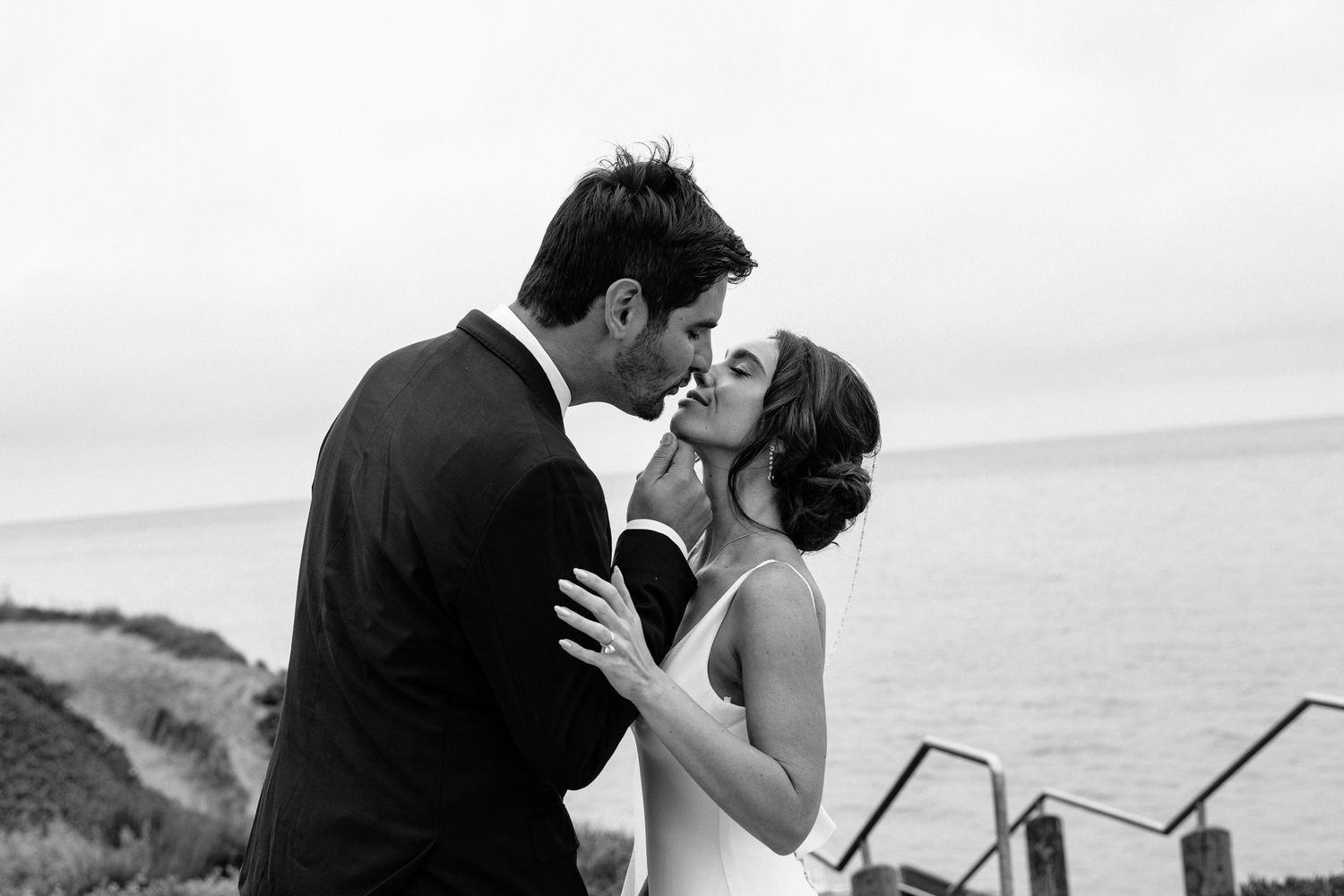 Romantic wedding couple shares intimate moments by the ocean.