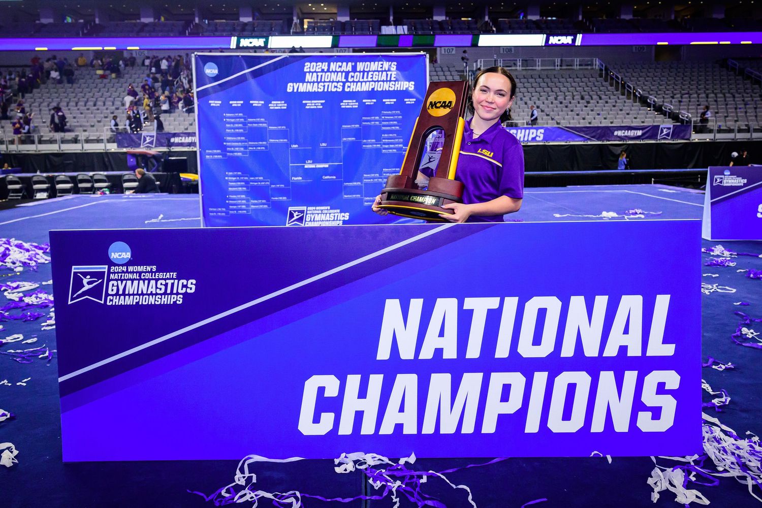 National Champions display sign in purple and white at sports arena.