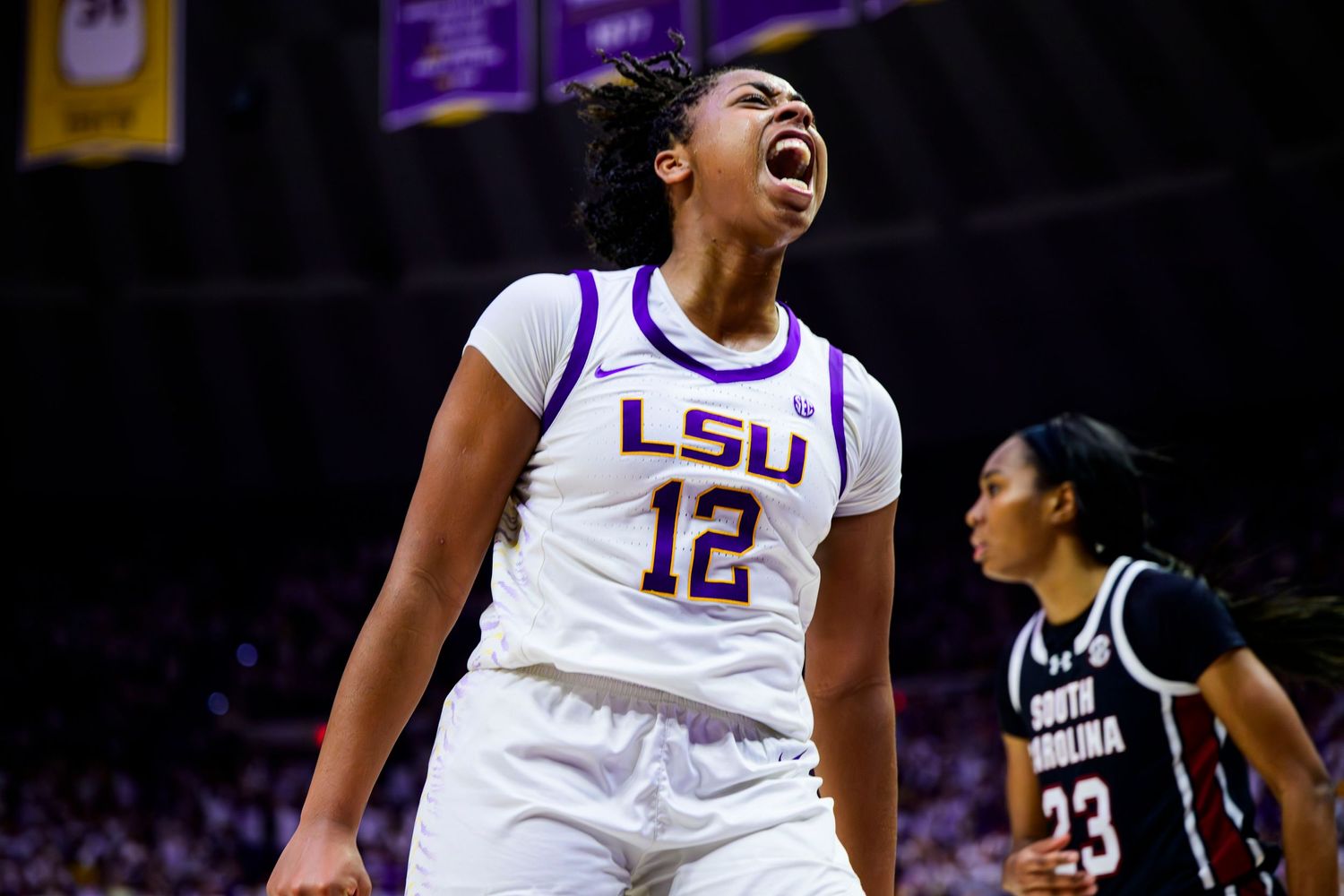 Basketball player celebrates intensely during LSU game wearing number 12 jersey.