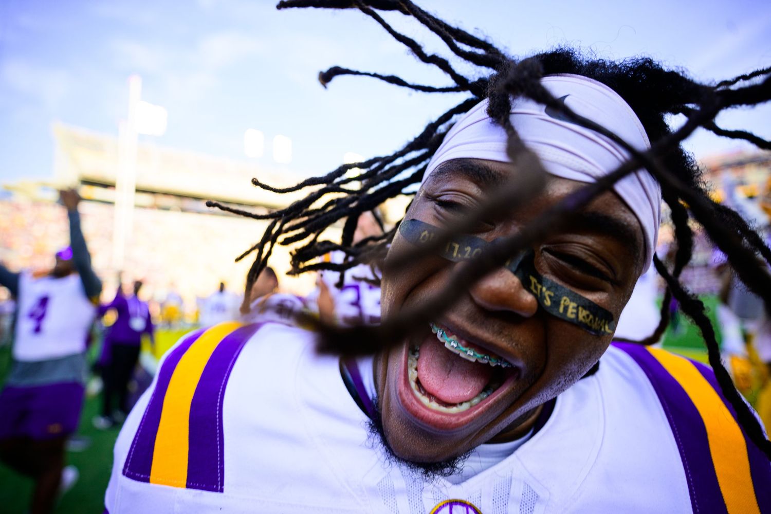 Football player celebrates with enthusiastic expression wearing LSU uniform.