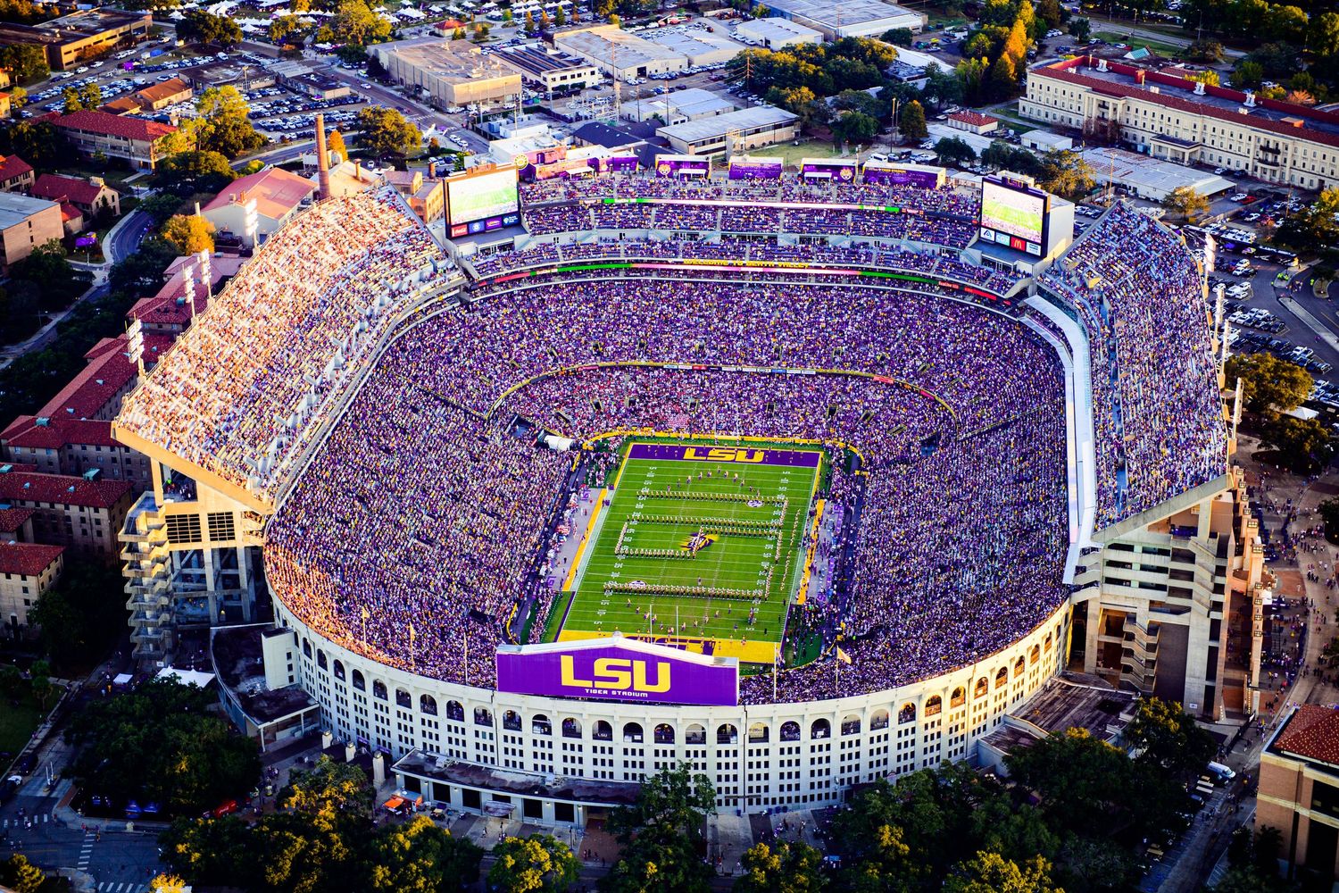 Aerial view of LSU's Tiger Stadium in Baton Rouge packed with fans during a night football game.