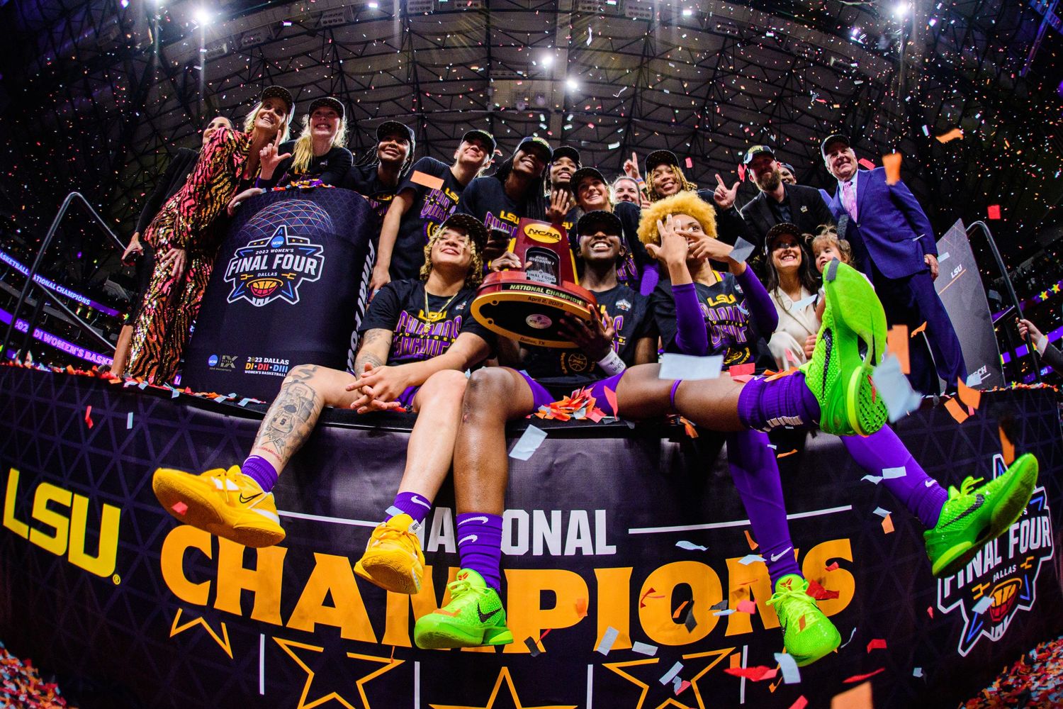 LSU team celebrates championship victory with trophy and confetti.
