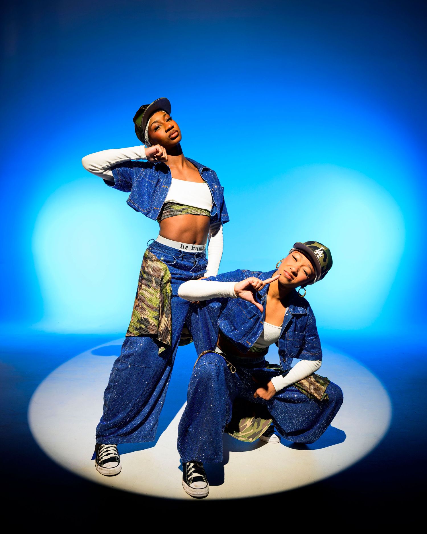 Dancer in baggy denim performs breakdancing moves in sequence against blue background with dramatic spotlight effect.