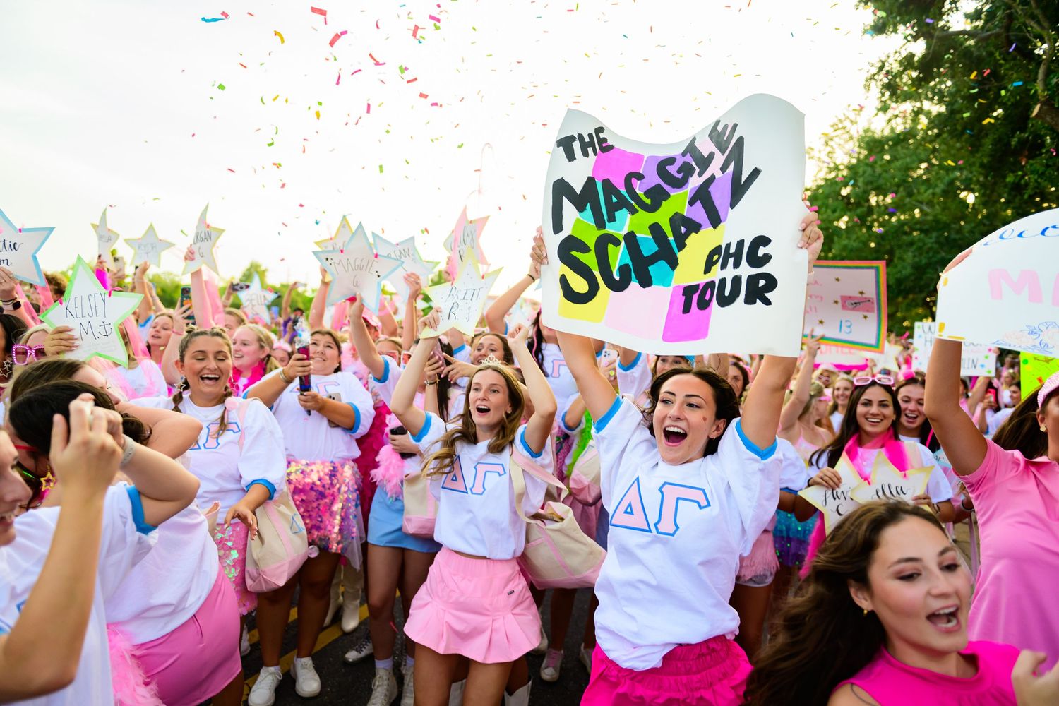 Participants celebrate at Color Run event with pink and colorful powder in the air.