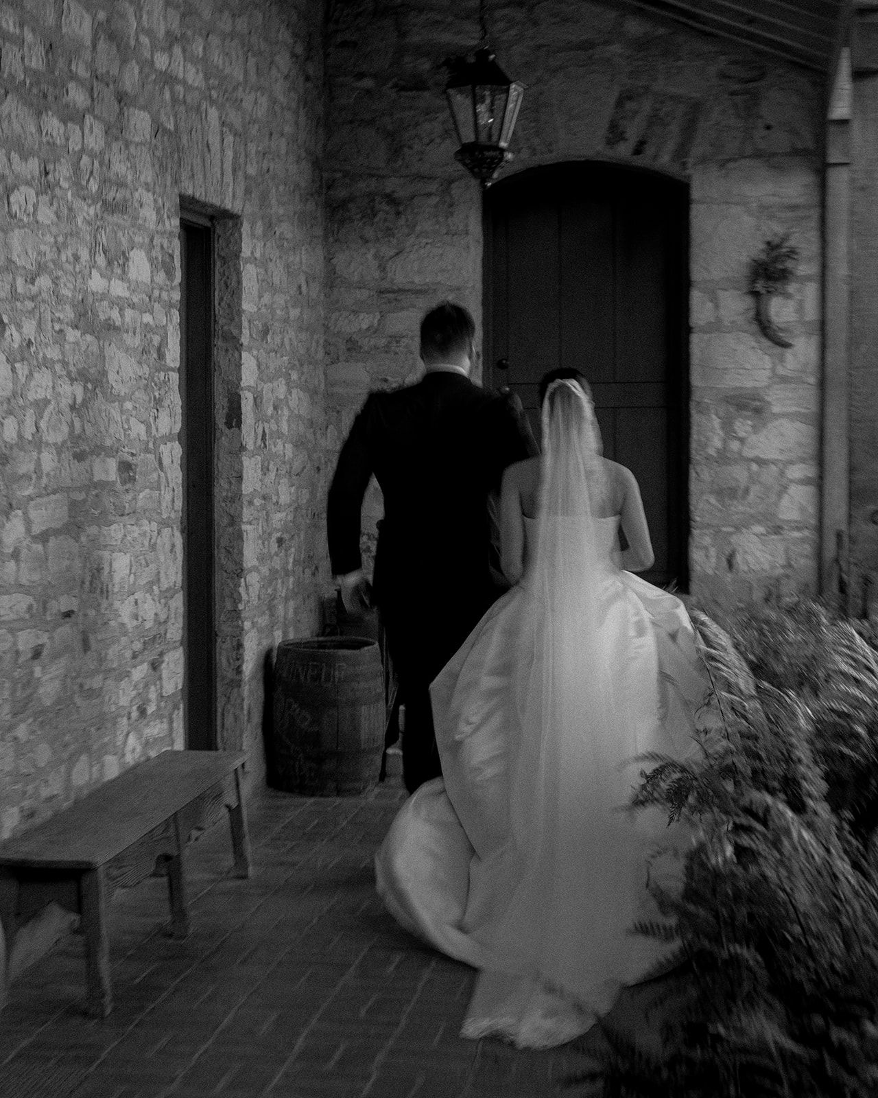 A ghostly figure in white moves through a dimly lit stone corridor creating an eerie atmosphere.