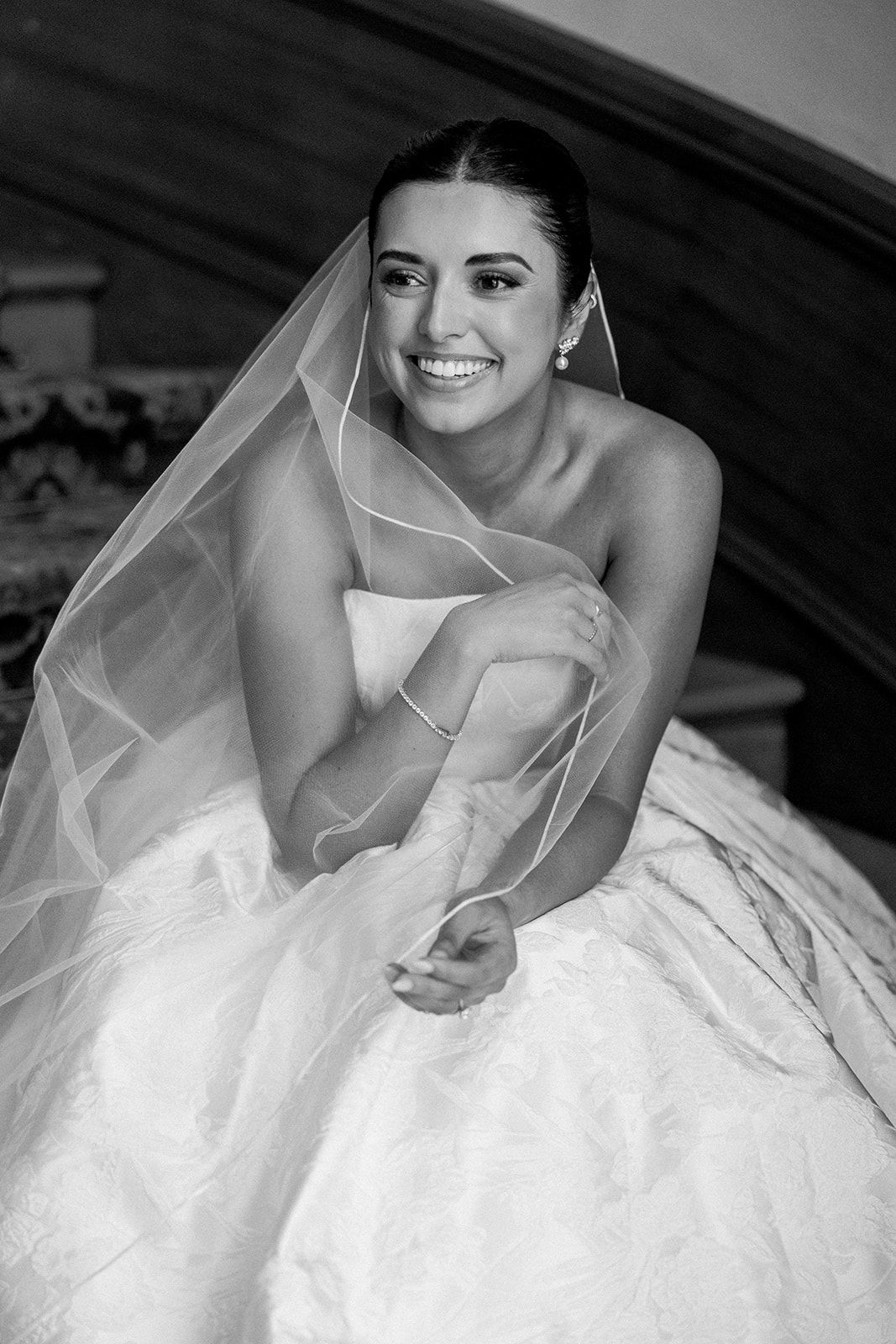 A series of black and white bridal portraits showing a woman in a white wedding dress leaning elegantly against a car.