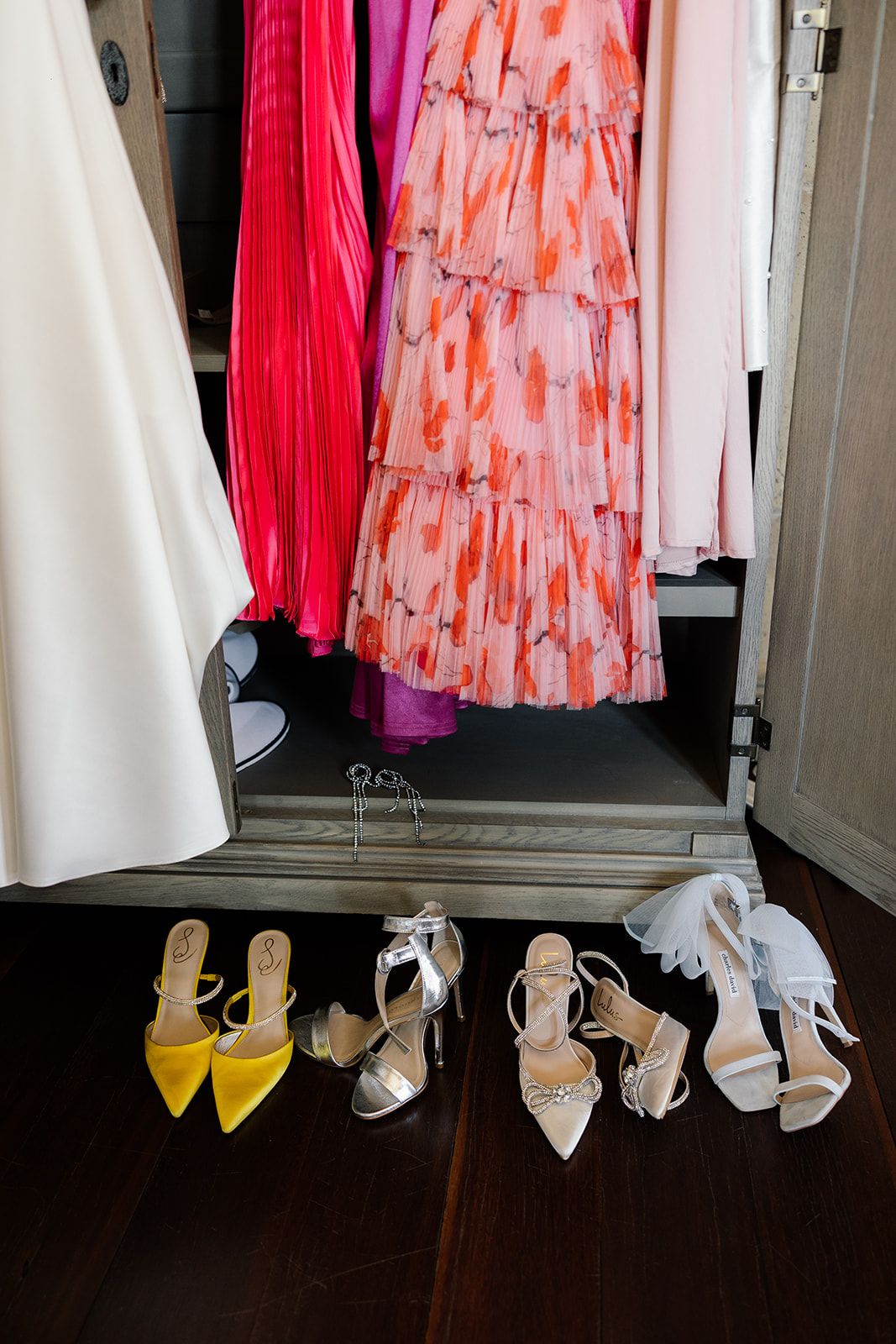 Collection of formal dresses and heels arranged for a wedding party.