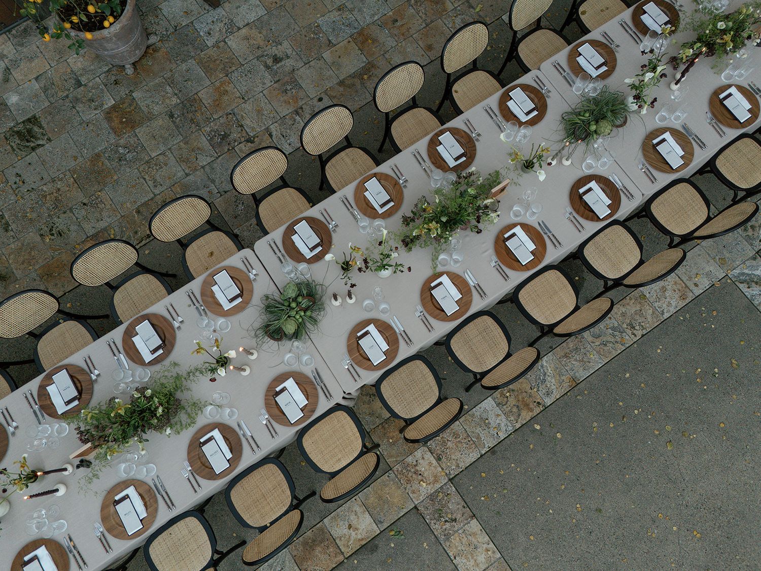 Aerial view of multiple tan chairs arranged in rows with red cushions on an outdoor patio or deck space.