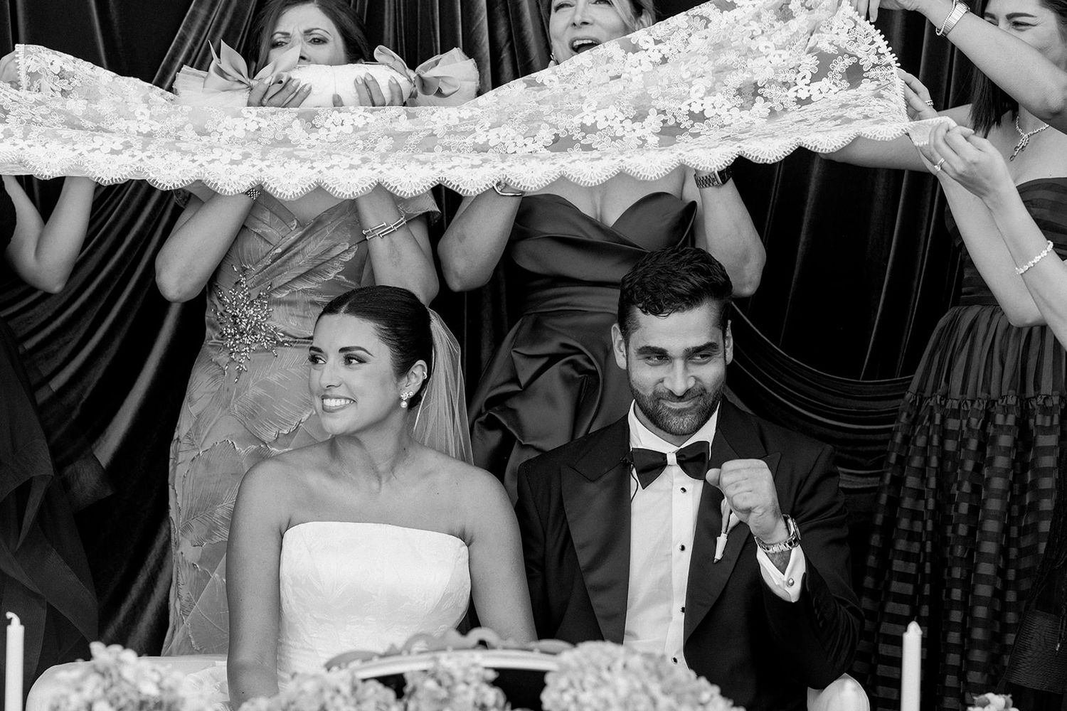 Wedding celebration captured in black and white with people dancing and enjoying the reception under a dotted tent.