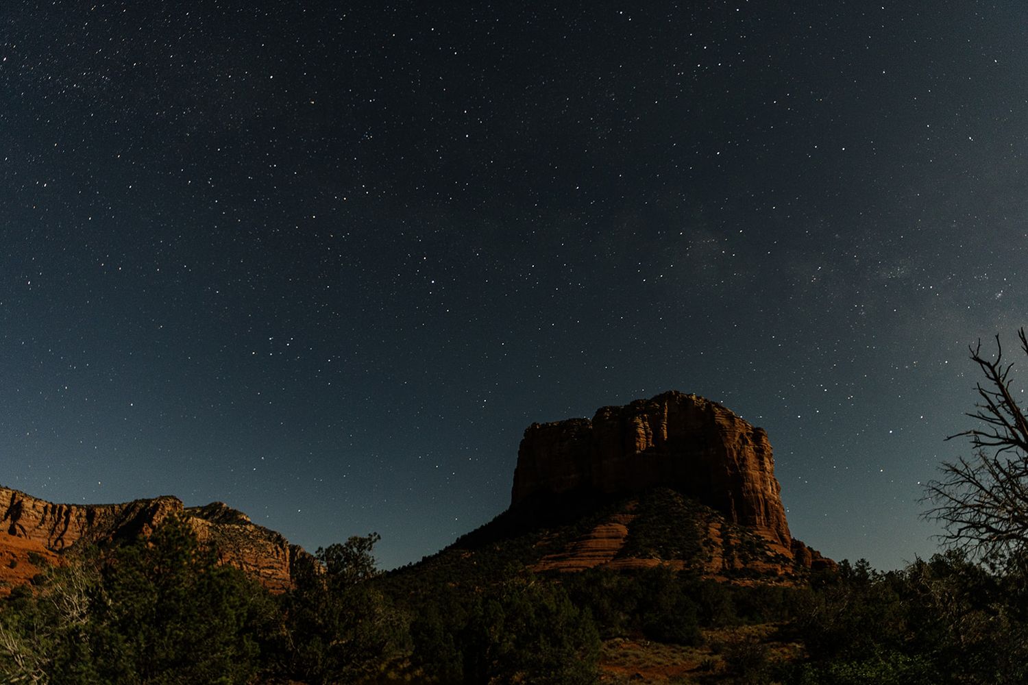 Red rocks at sunset in Sedona Arizona cast long shadows against the desert landscape as night approaches.