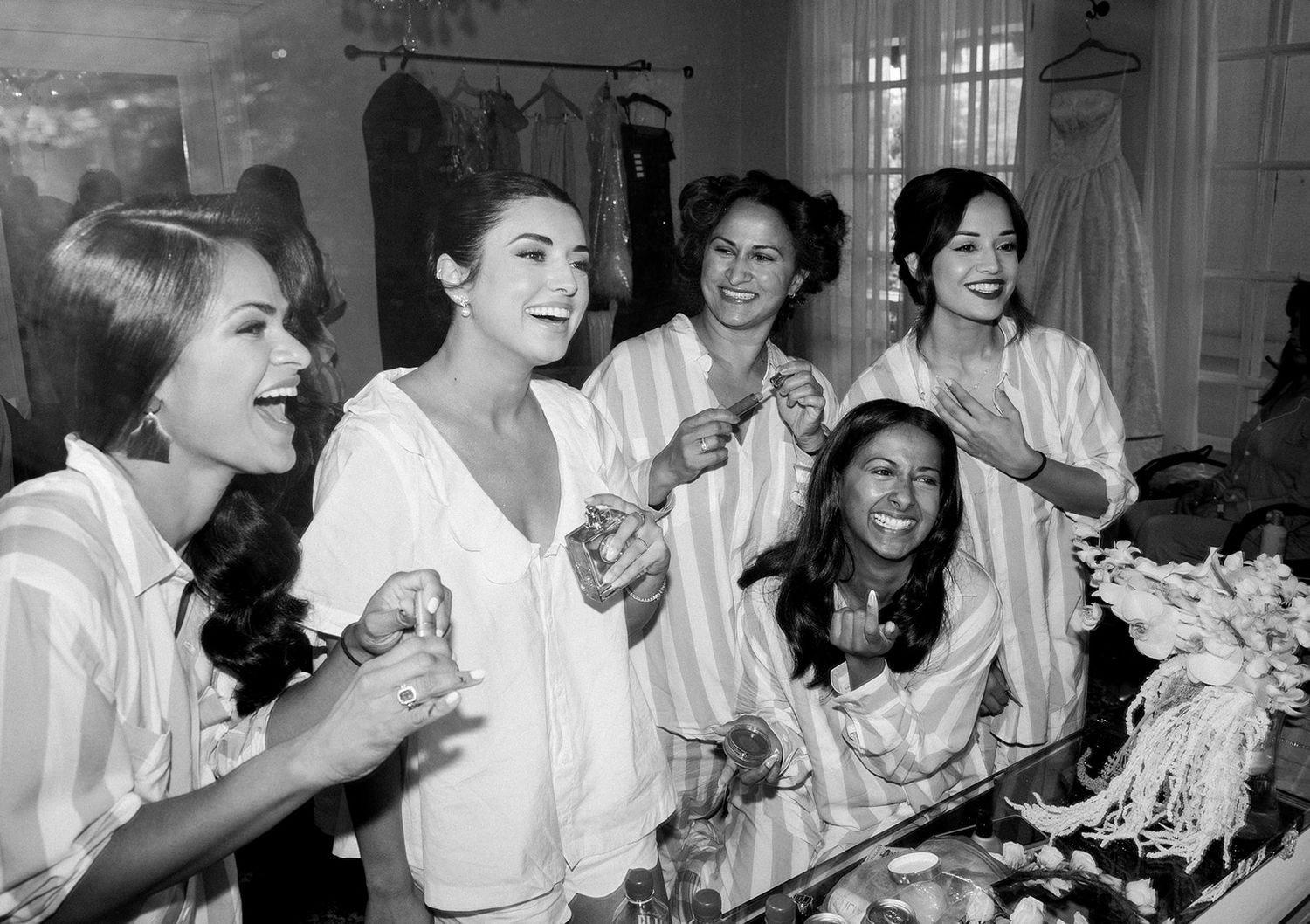 Several people laugh together while sitting in a white uniformed setting.