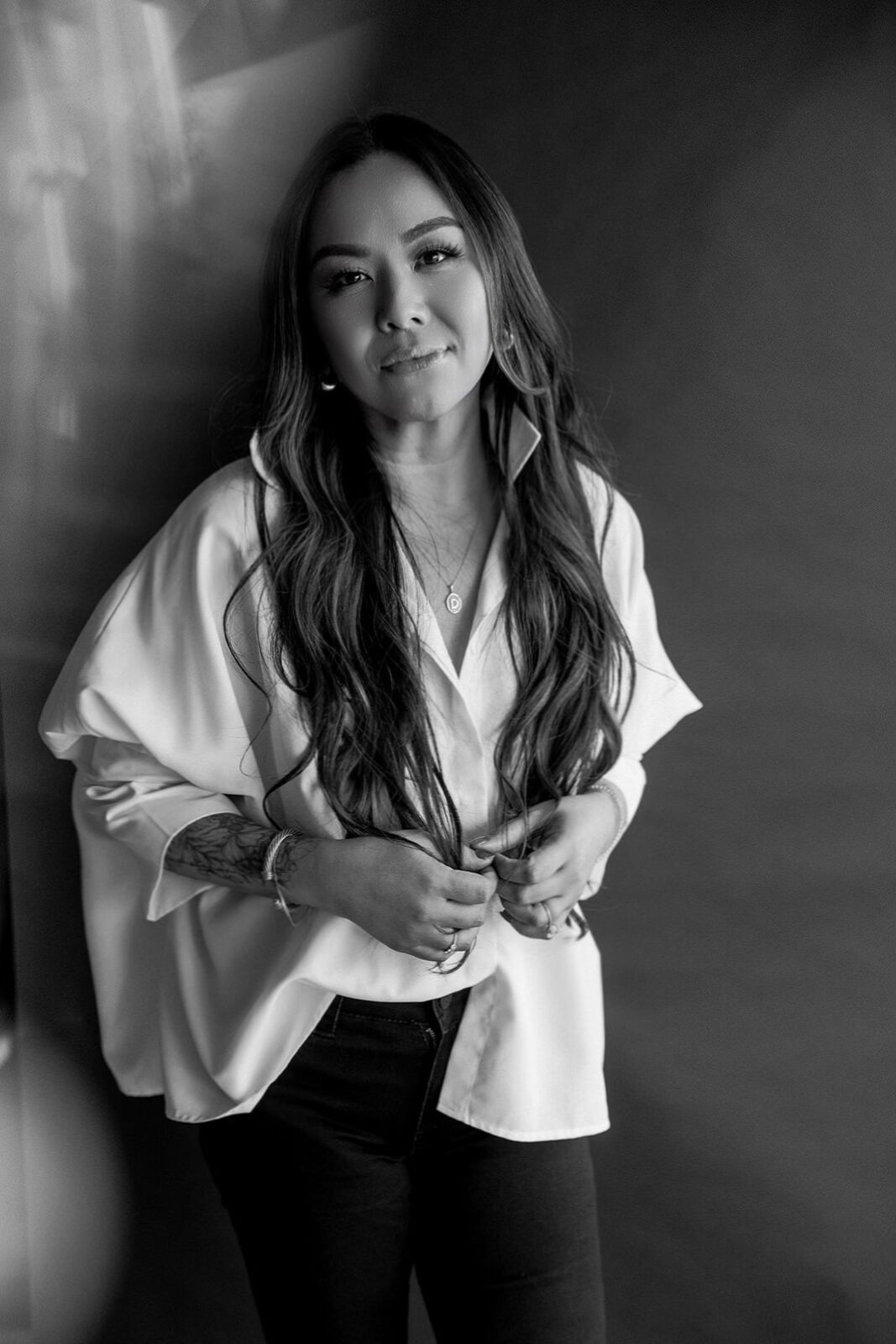 Black and white portrait series showing a person in a white shirt and dark pants striking different poses against a dark background.