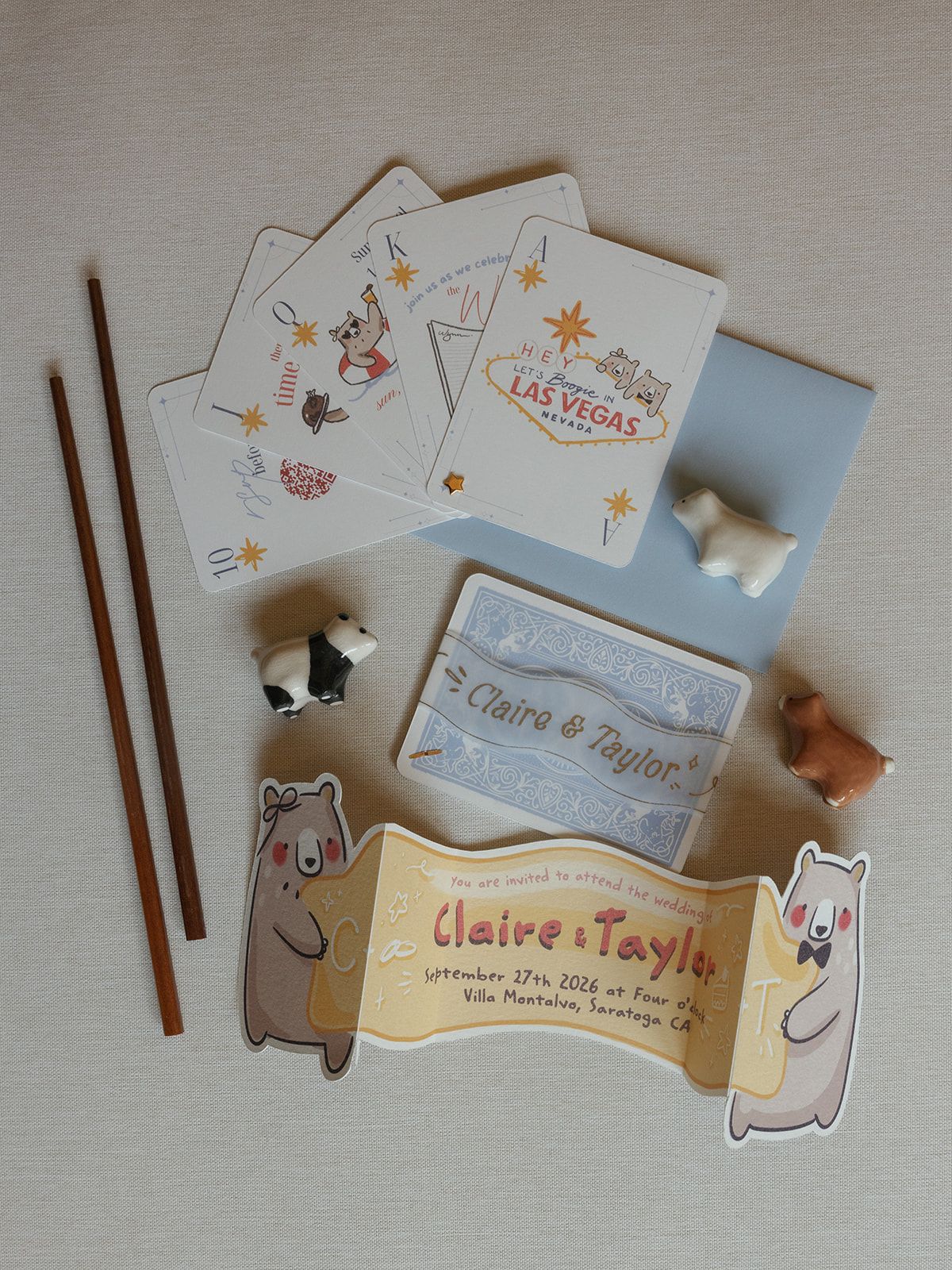 Wedding invitation suite for Claire and Taylor featuring playing cards, chopsticks, animal figurines, and custom bear stickers.