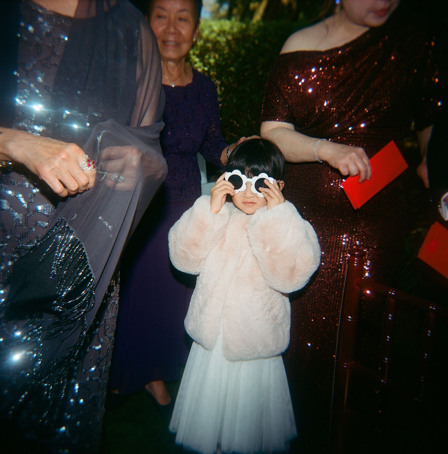 Young guest in white dress and sunglasses enjoying a festive wedding reception.