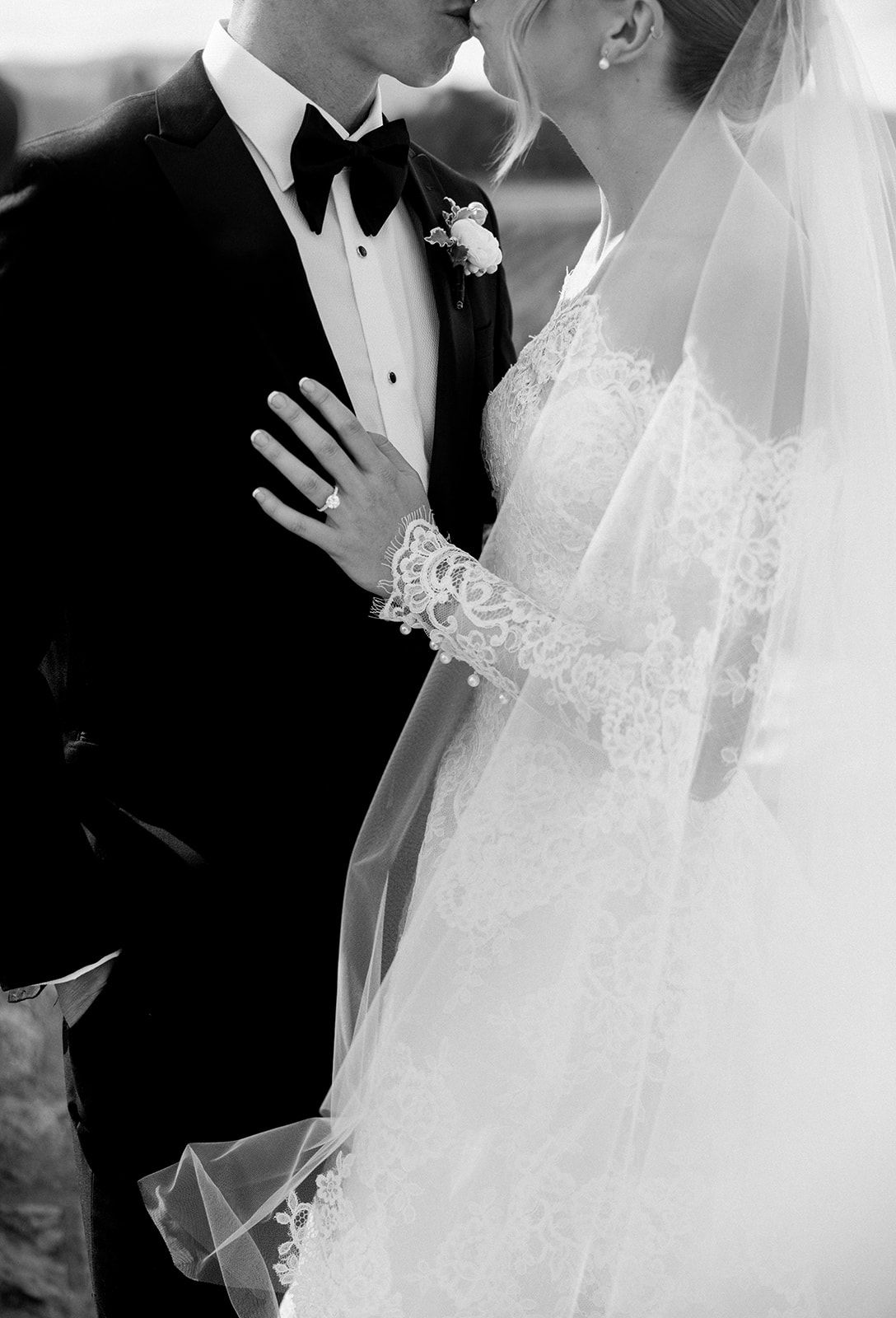 Intimate black and white close-up of couple in wedding attire.