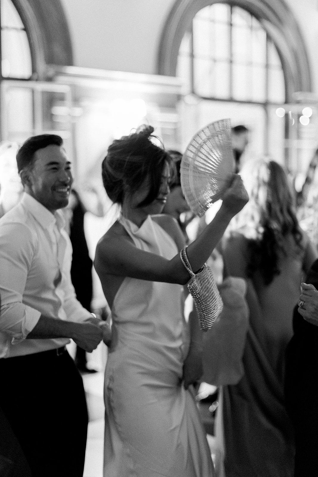 Black and white photo sequence of people dancing and celebrating at a wedding reception.